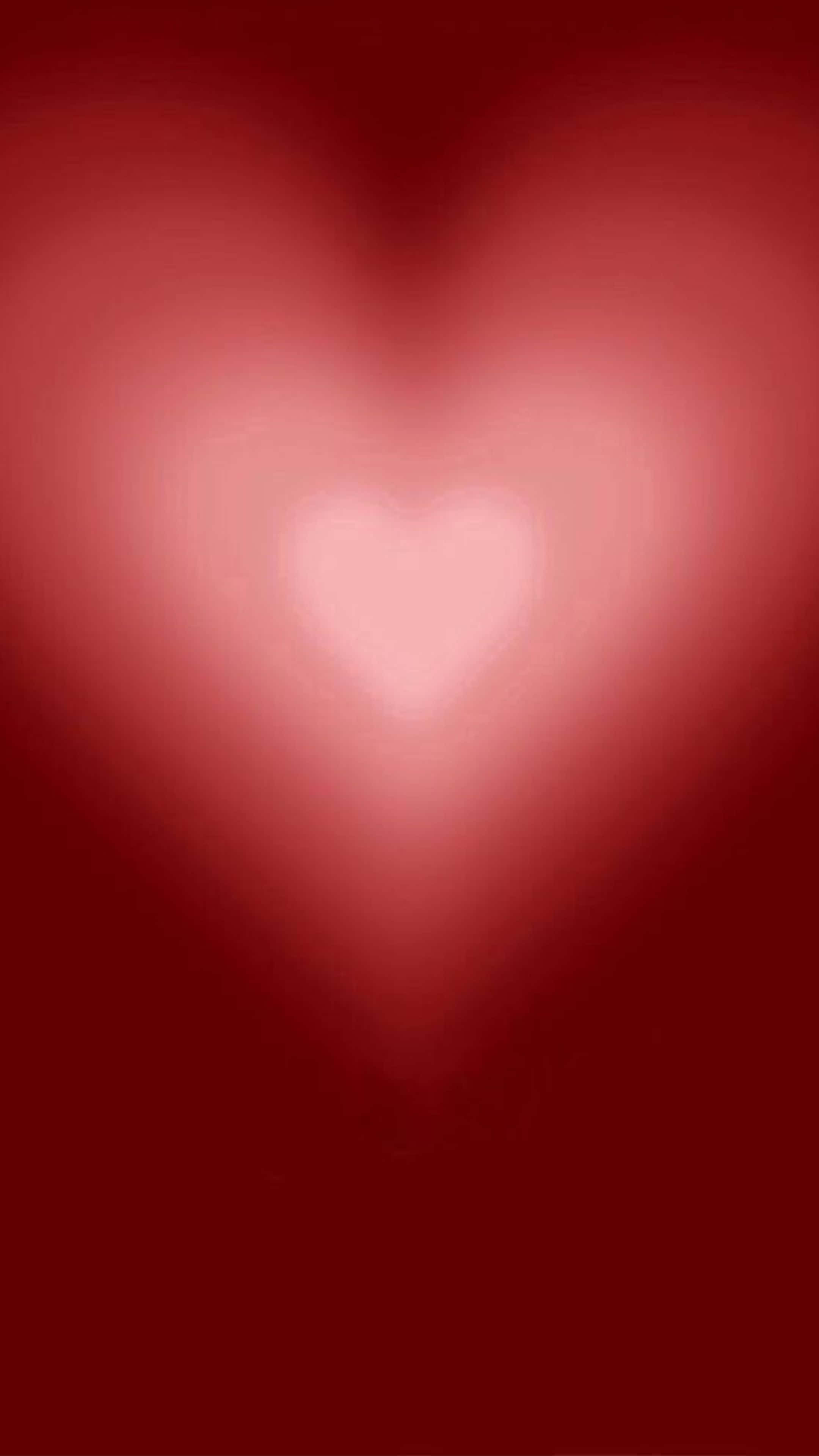 Red Hearts 桌布 壁紙 — 一顆發光的心臟在深紅色漸變背景上散發出柔和的粉紅色光芒。