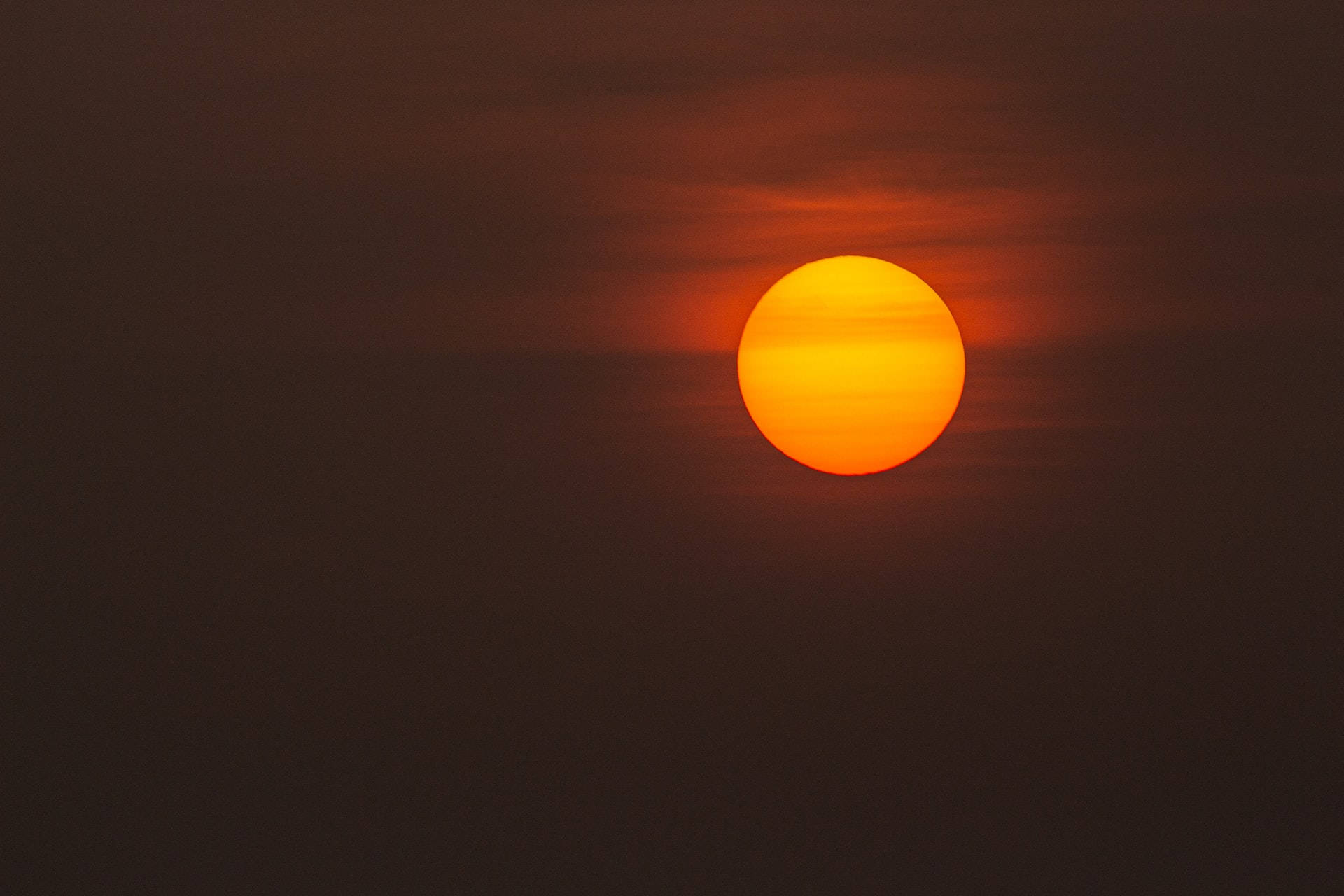 太陽 桌布 壁紙 — 一顆發光的橙色太陽在黃昏時分透過漸暗的天空散發溫暖。