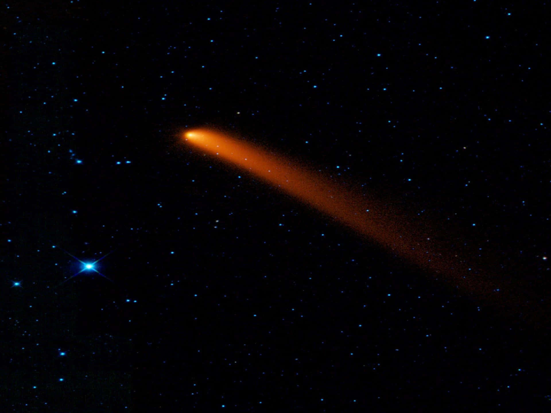 comet 桌布 壁紙 — 一顆發光的橙色彗星劃過星空，附近有一顆明亮的藍色星星，背景是黑色的天空。