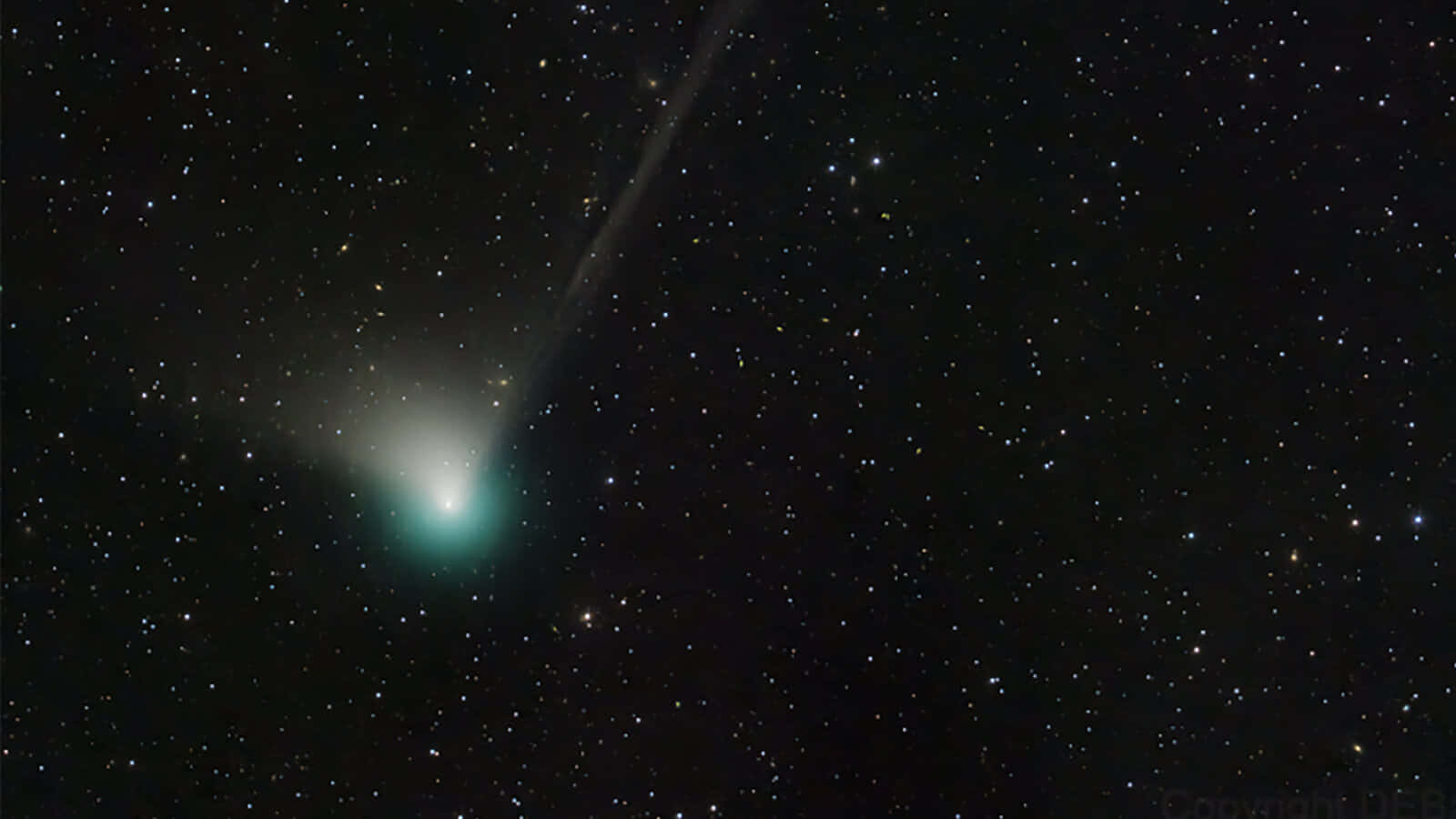 外太空 桌布 壁紙 — 一顆發光的綠色彗星劃過滿天星斗的夜空，明亮的尾巴呈對角線延伸。