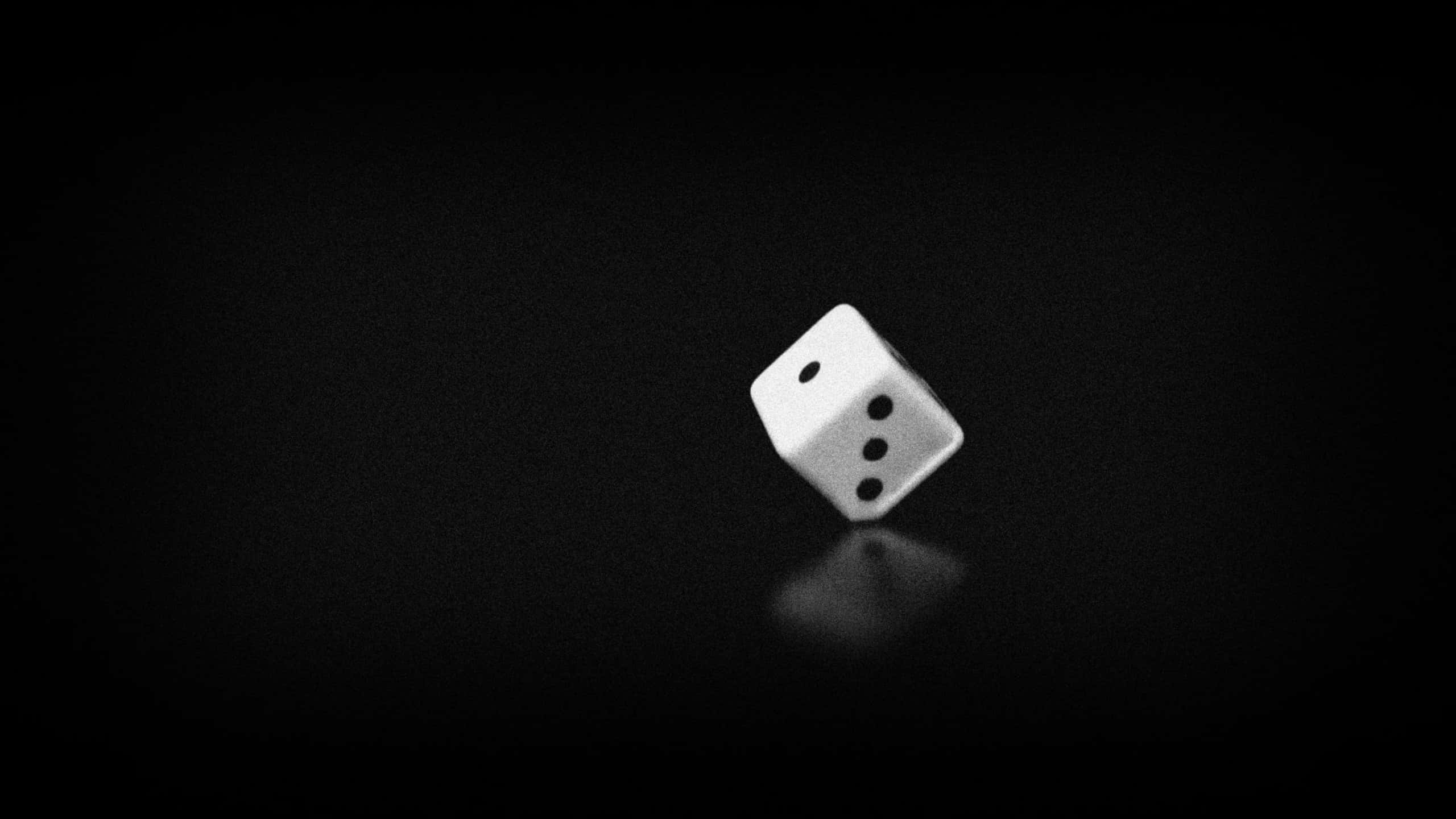 Dice 桌布 壁紙 — 一顆白色骰子，上面有三點，在純黑反光表面上旋轉。