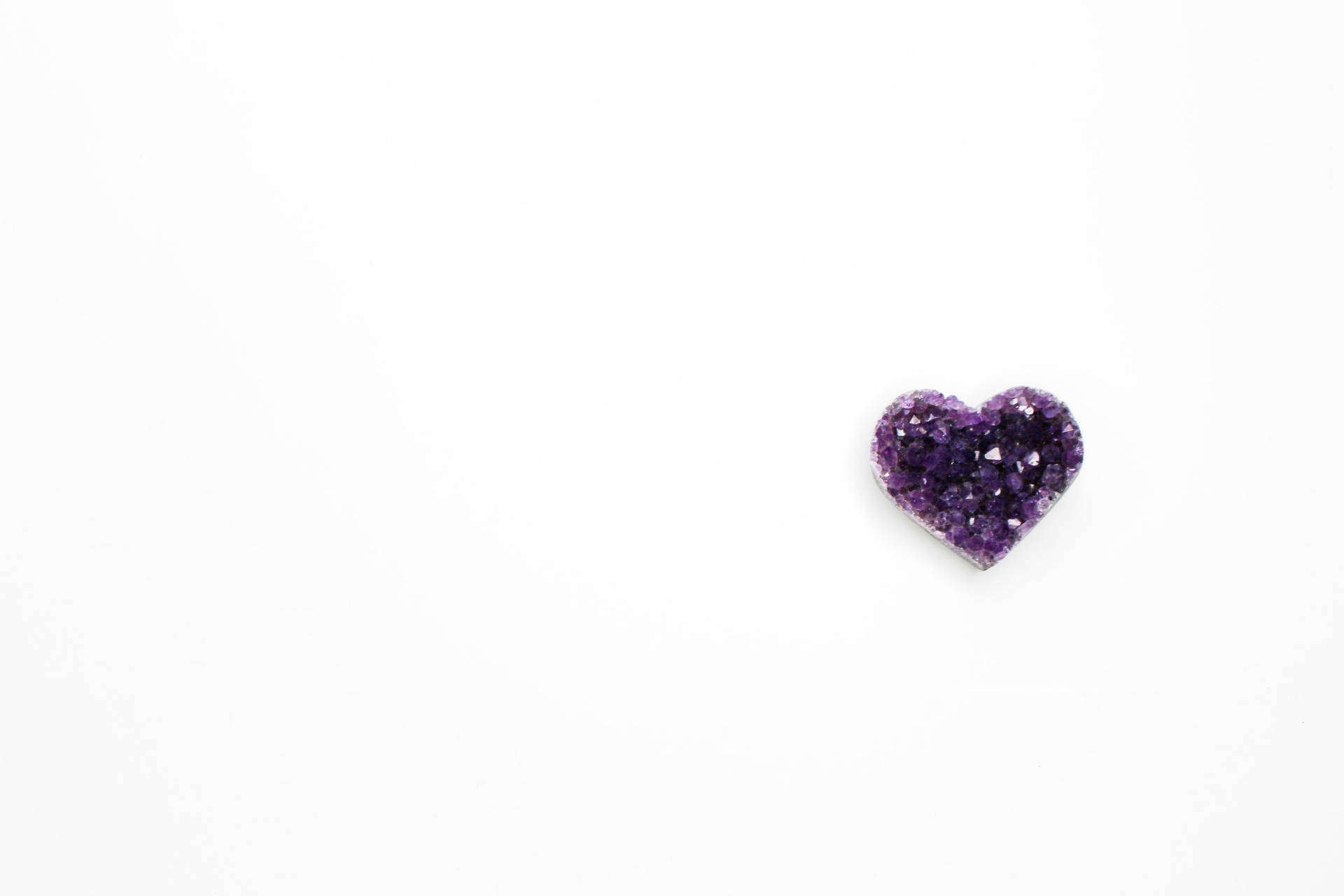 Crystal 桌布 壁紙 — 一顆細小的心形紫色紫晶洞單獨放在純白色背景上。