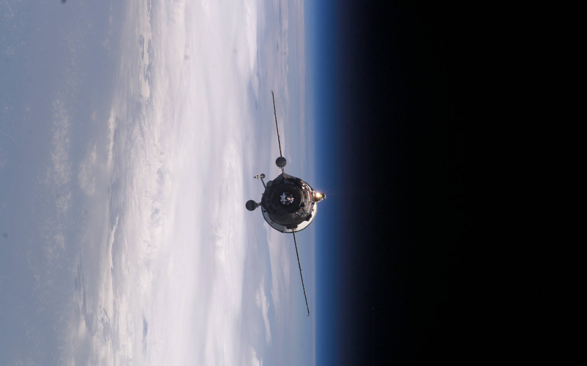 nasa 美學 桌布 壁紙 — 一顆衛星在漆黑的太空中繞地球運行，下方是彎曲的藍色大氣層和白色雲層。