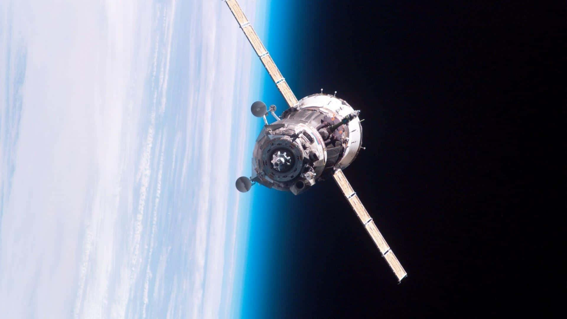 Satellite 桌布 壁紙 — 一顆詳細的衛星繞地球運行，顯示地球的藍色曲線與太空的黑色虛空。