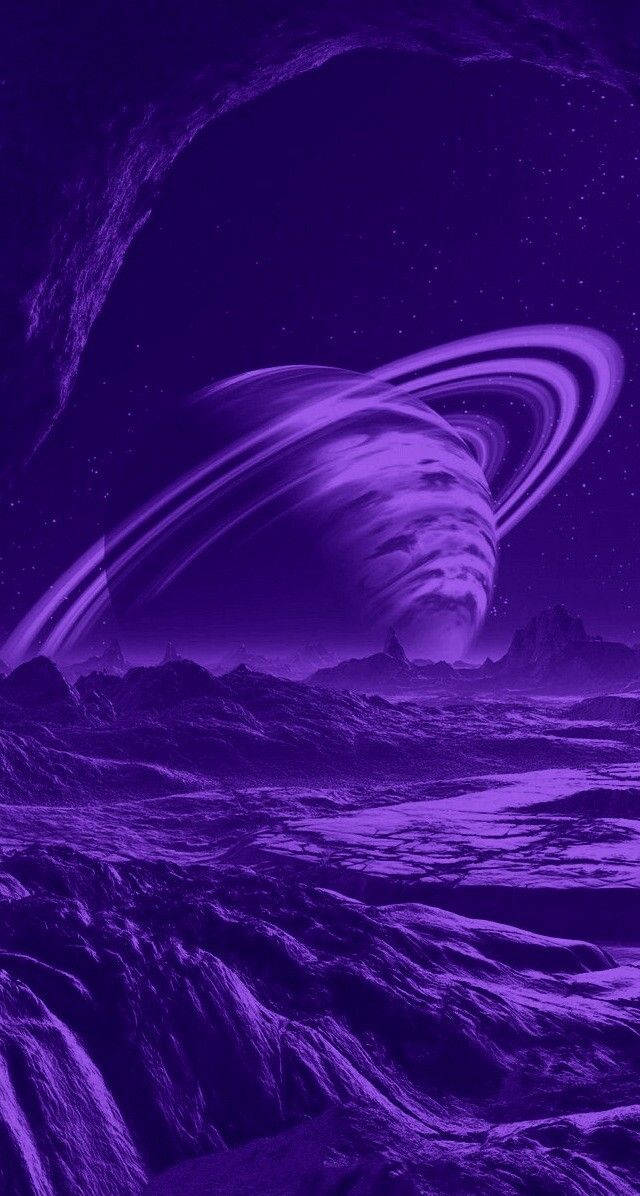 月光 桌布 壁紙 — 一顆超現實的紫色行星帶著發光的環，在星空下籠罩著崎嶇的外星景觀。