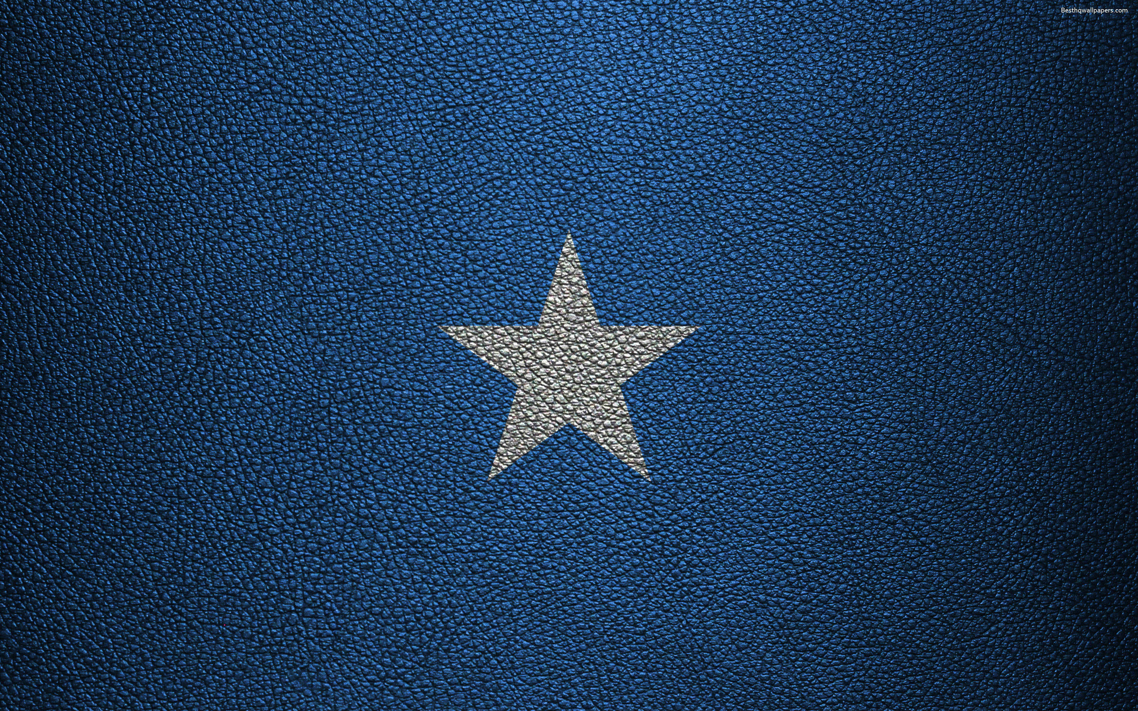 Somalia 桌布 壁紙 — 一顆銀色星星壓印在帶有紋理的深藍色皮革背景上。