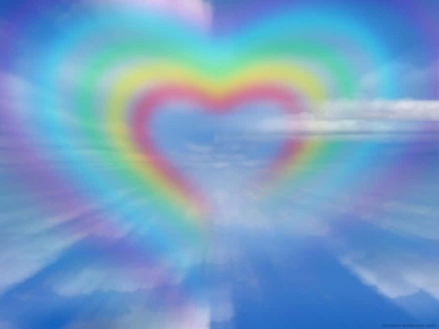Rainbow Heart 桌布 壁紙 — 一顆閃耀的心形彩虹在夢幻的藍天中柔和發光，伴隨著縷縷薄雲。