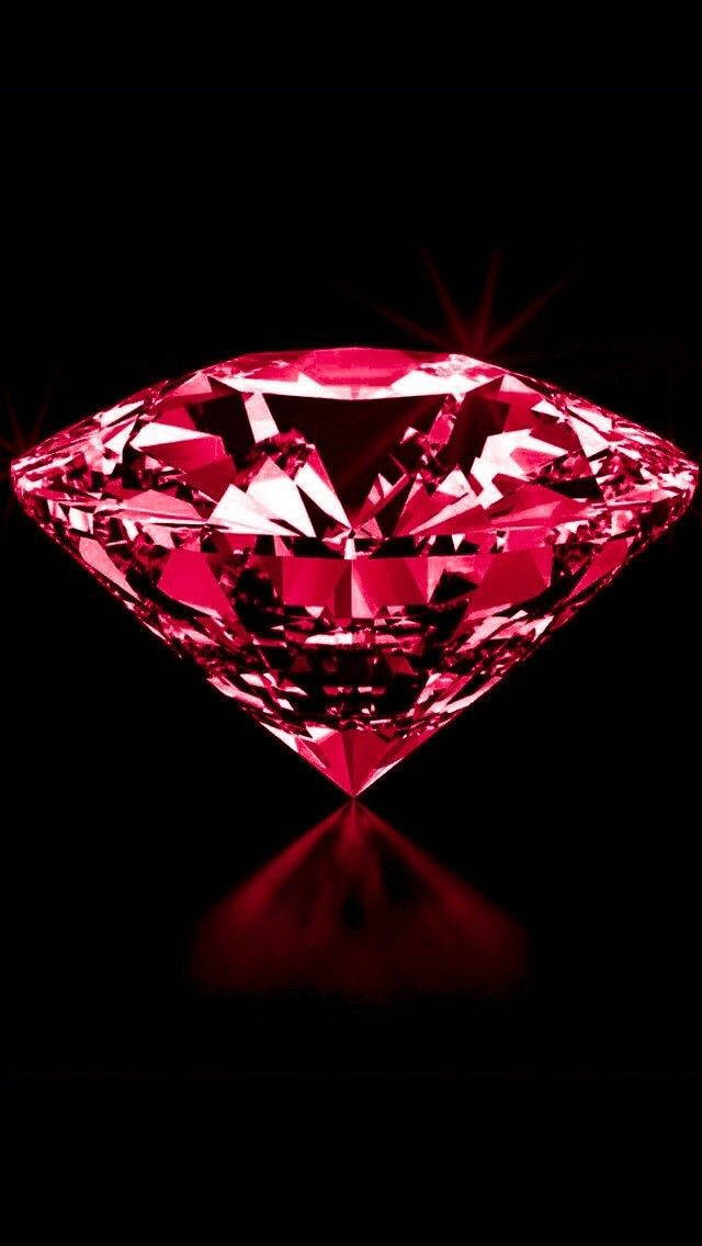 Red Crystal 桌布 壁紙 — 一顆閃耀的粉紅色鑽石，在純黑色背景上閃爍著銳利的切割面，下方投射出柔和的紅色倒影。
