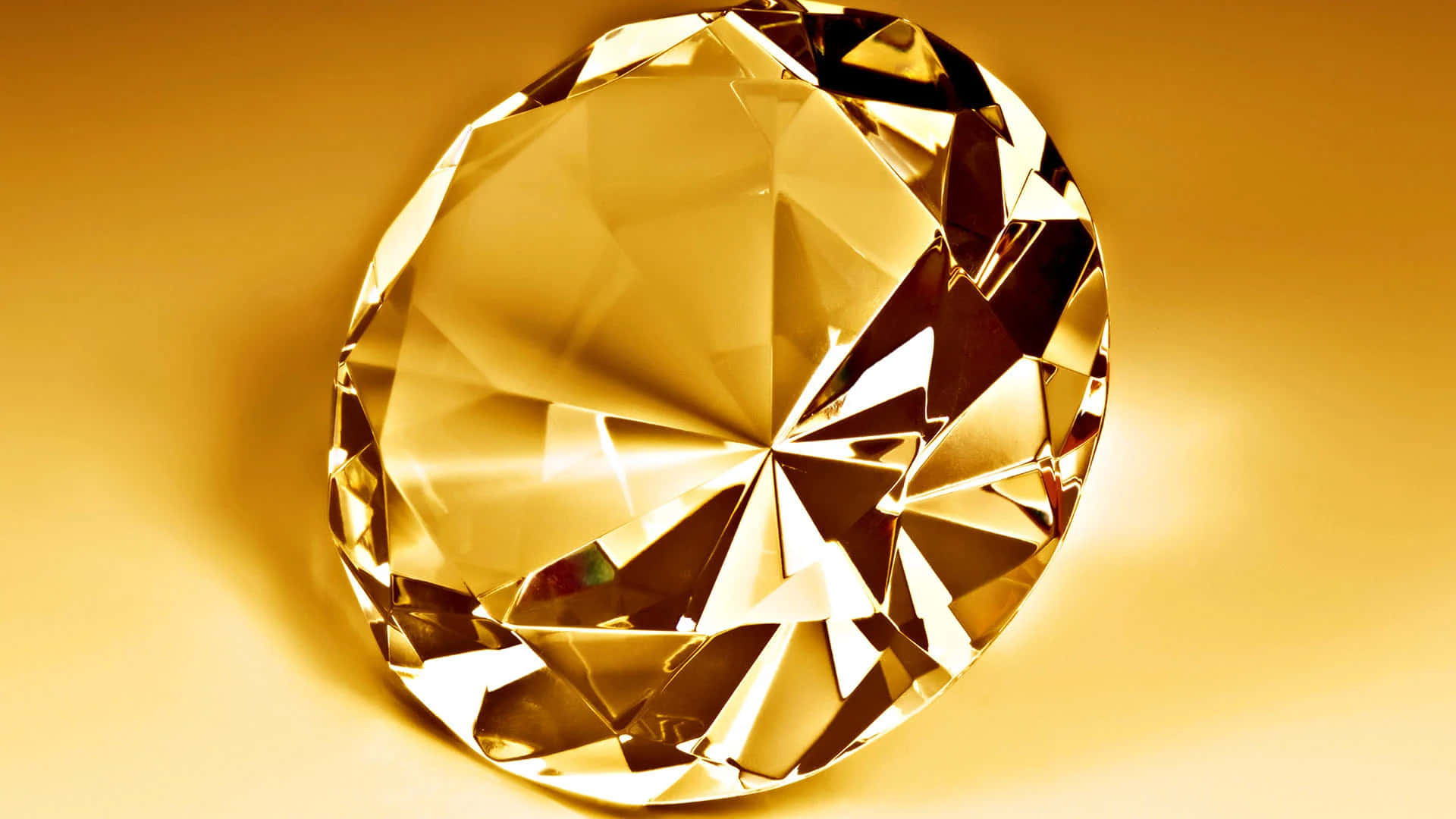 Yellow Diamond 桌布 壁紙 — 一顆閃耀的金色鑽石，帶有鋒利的刻面，在溫暖的漸變背景上閃爍。