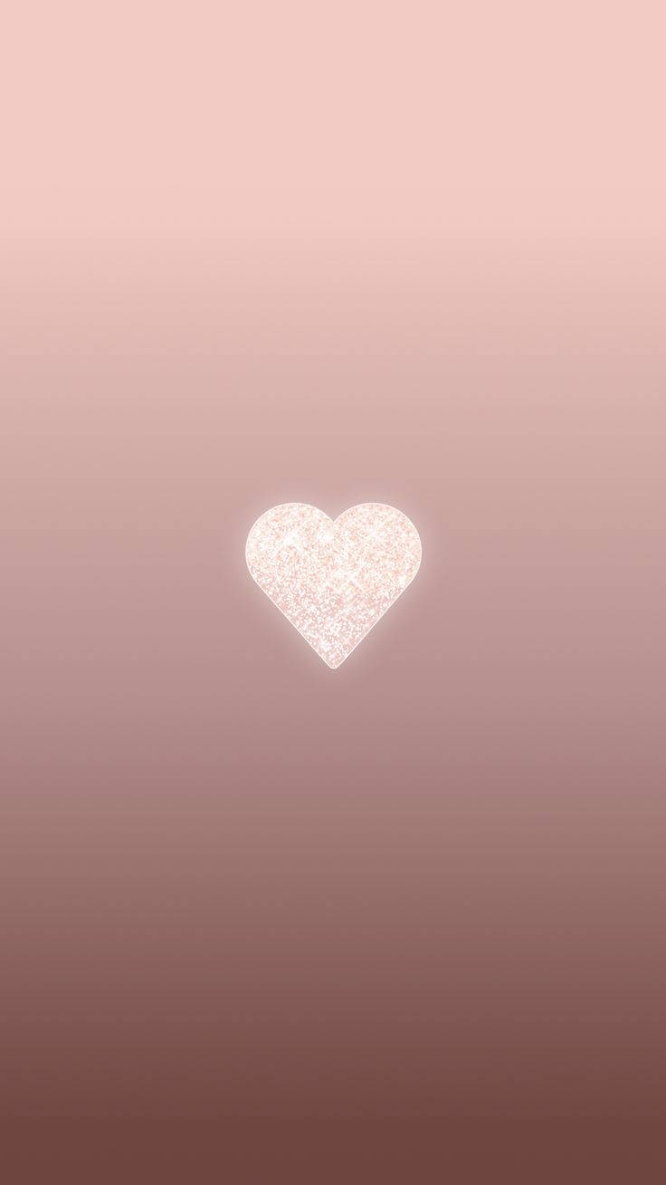 一顆發光的亮片心在柔和的粉紅到淡紫色漸層背景上。 — 心形美學 GIF 壁紙