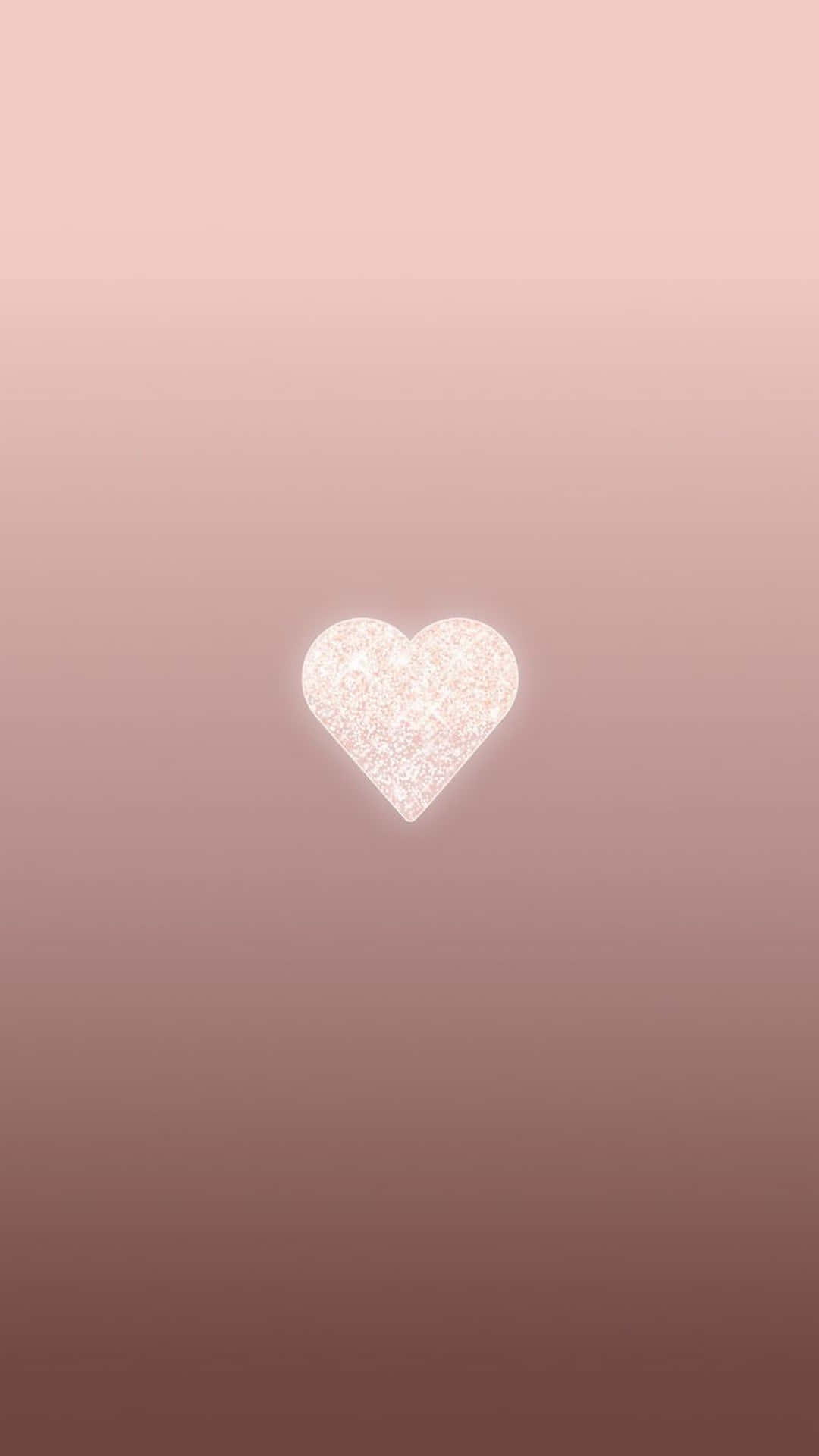 Aesthetic Rose Gold 桌布 壁紙 — 一顆閃閃發光的白色心形在玫瑰金色漸變背景上柔和地發光。