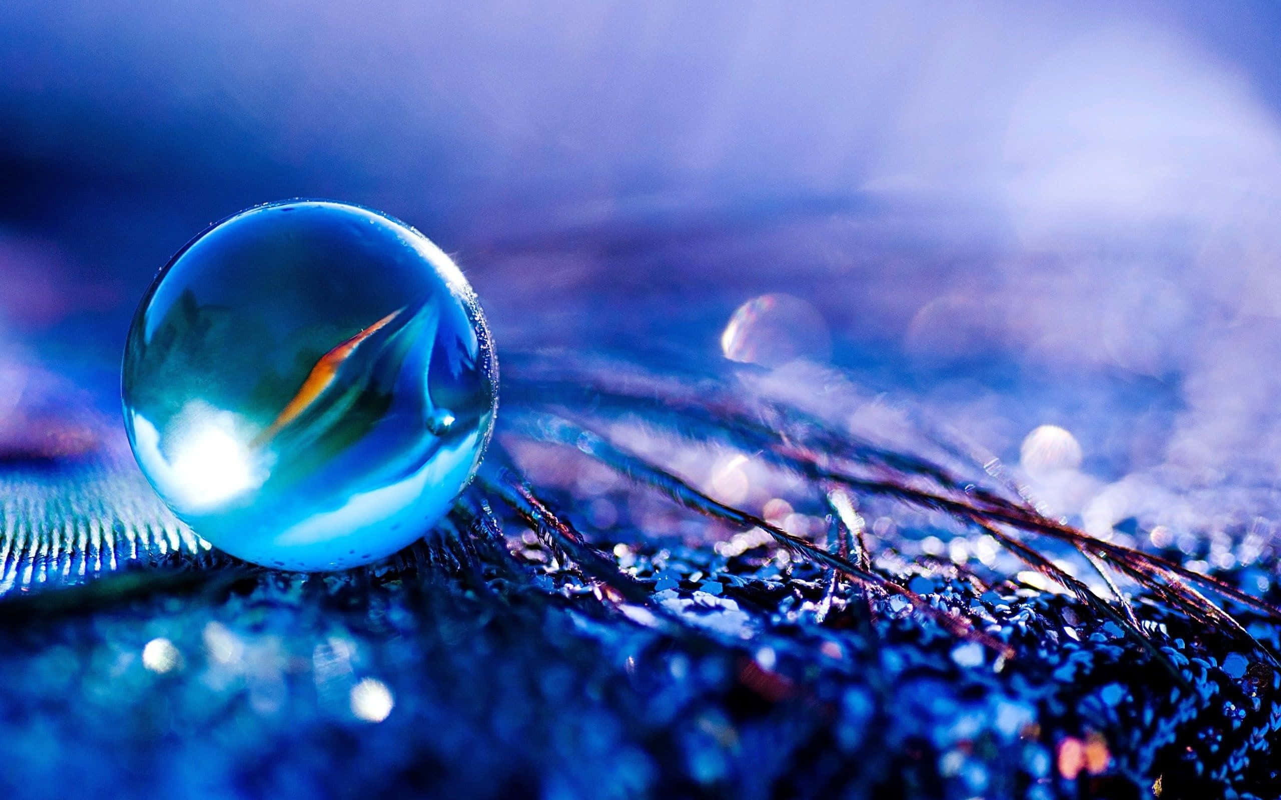 Crystal Ball 桌布 壁紙 — 一顆閃閃發光的藍色玻璃球體放置在紋理表面上，反射出鮮豔的光線和抽象的環境。