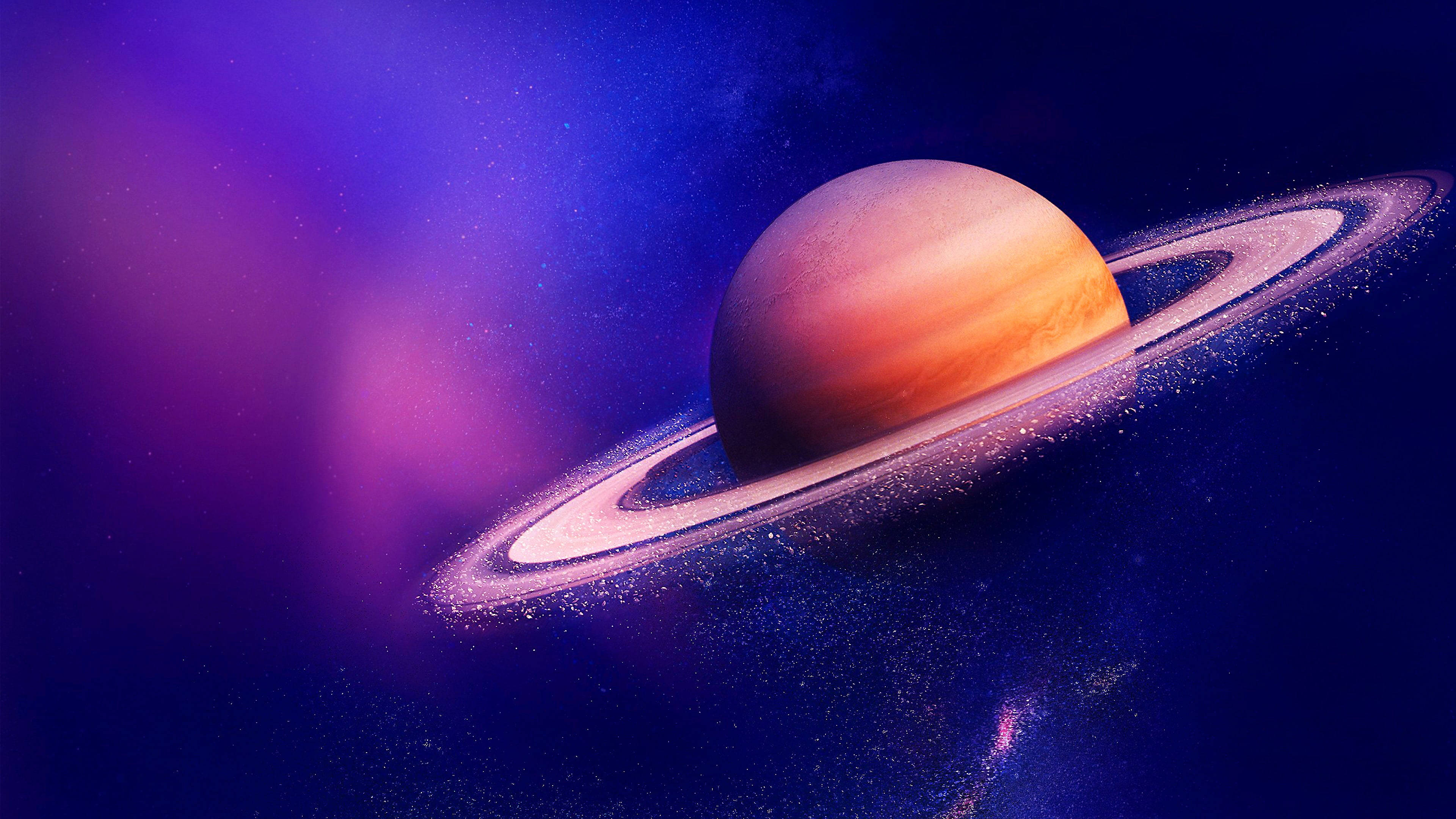 太空 桌布 壁紙 — 一顆雄偉的土星帶有發光的光環，漂浮在深紫色和藍色星星的宇宙星雲中。
