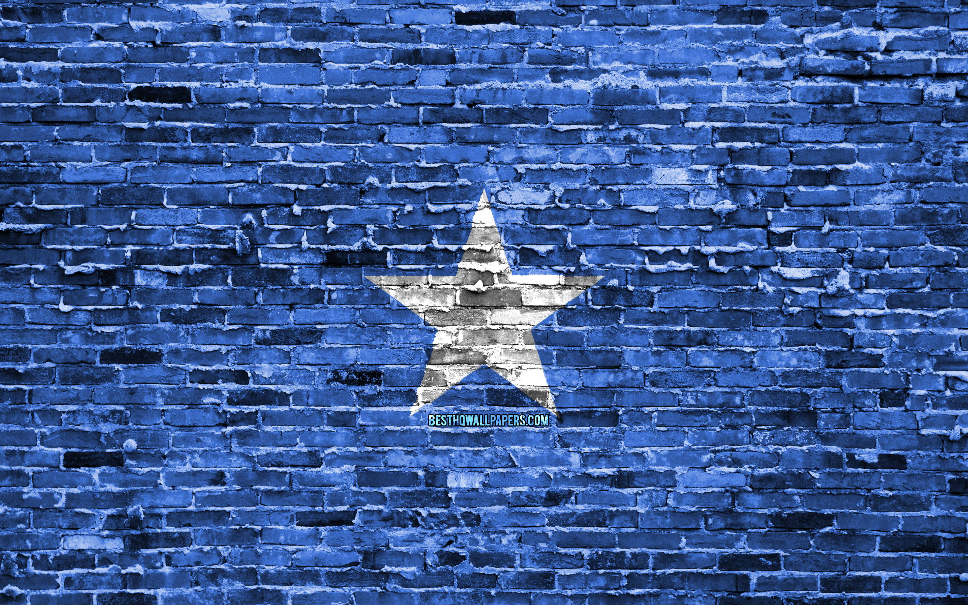 Somalia 桌布 壁紙 — 一顆風化的白色星星畫在帶有紋理的藍色磚牆上，油漆剝落，灰泥線條粗糙。