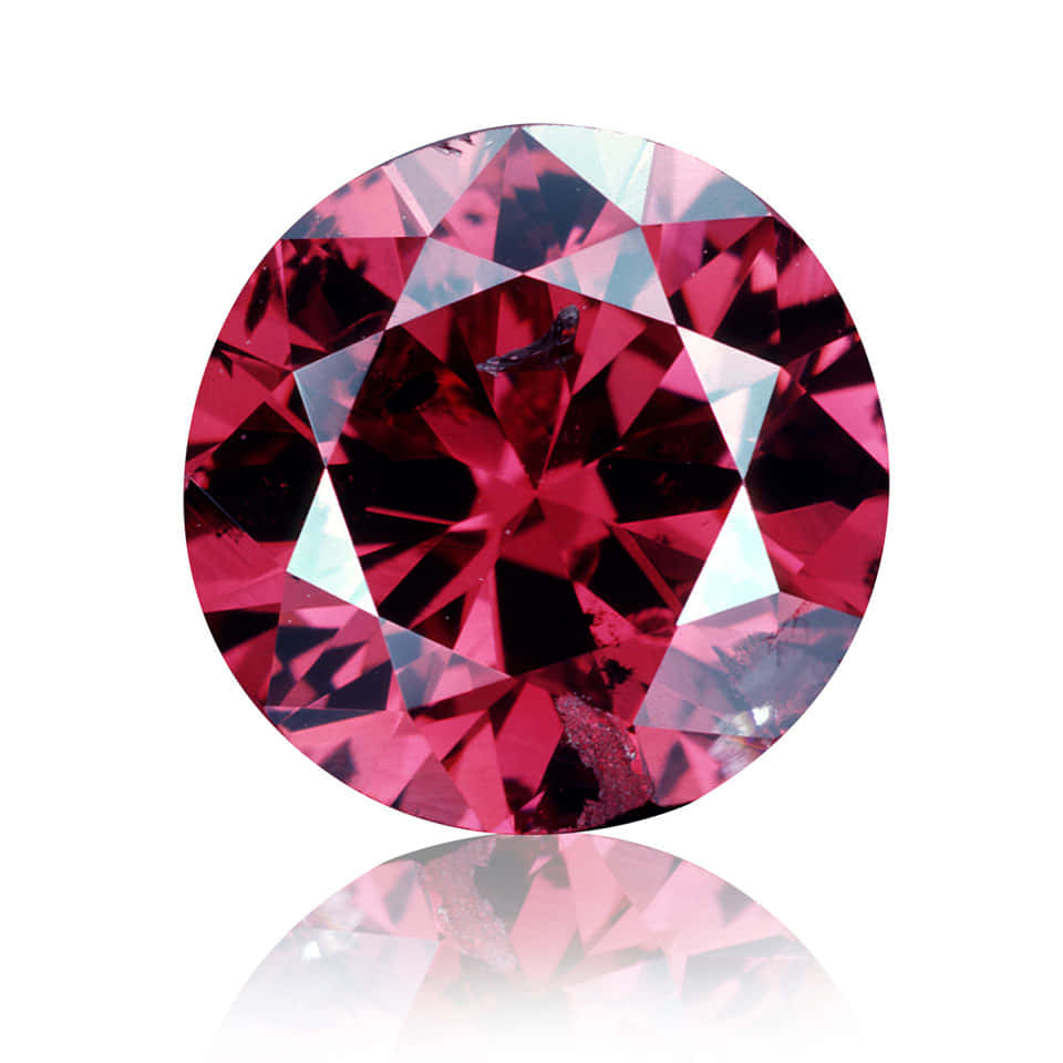 Red Diamond 桌布 壁紙 — 一顆鮮明切割的圓形粉紅寶石，帶有深洋紅色刻面，在純白背景上閃耀，並有柔和反射。