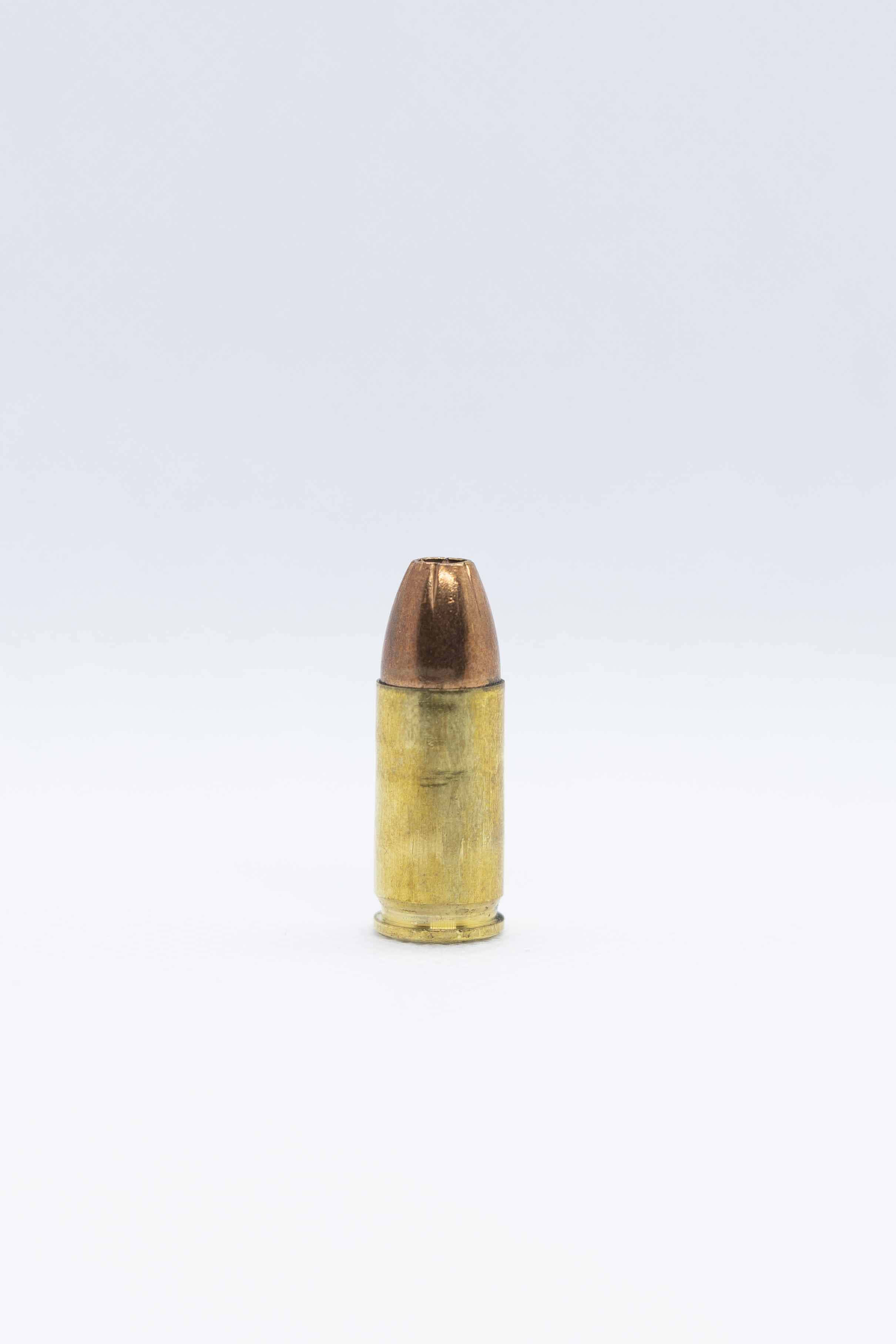 bullet 桌布 壁紙 — 一顆黃銅彈殼、銅被甲的子彈豎立在純白背景上。