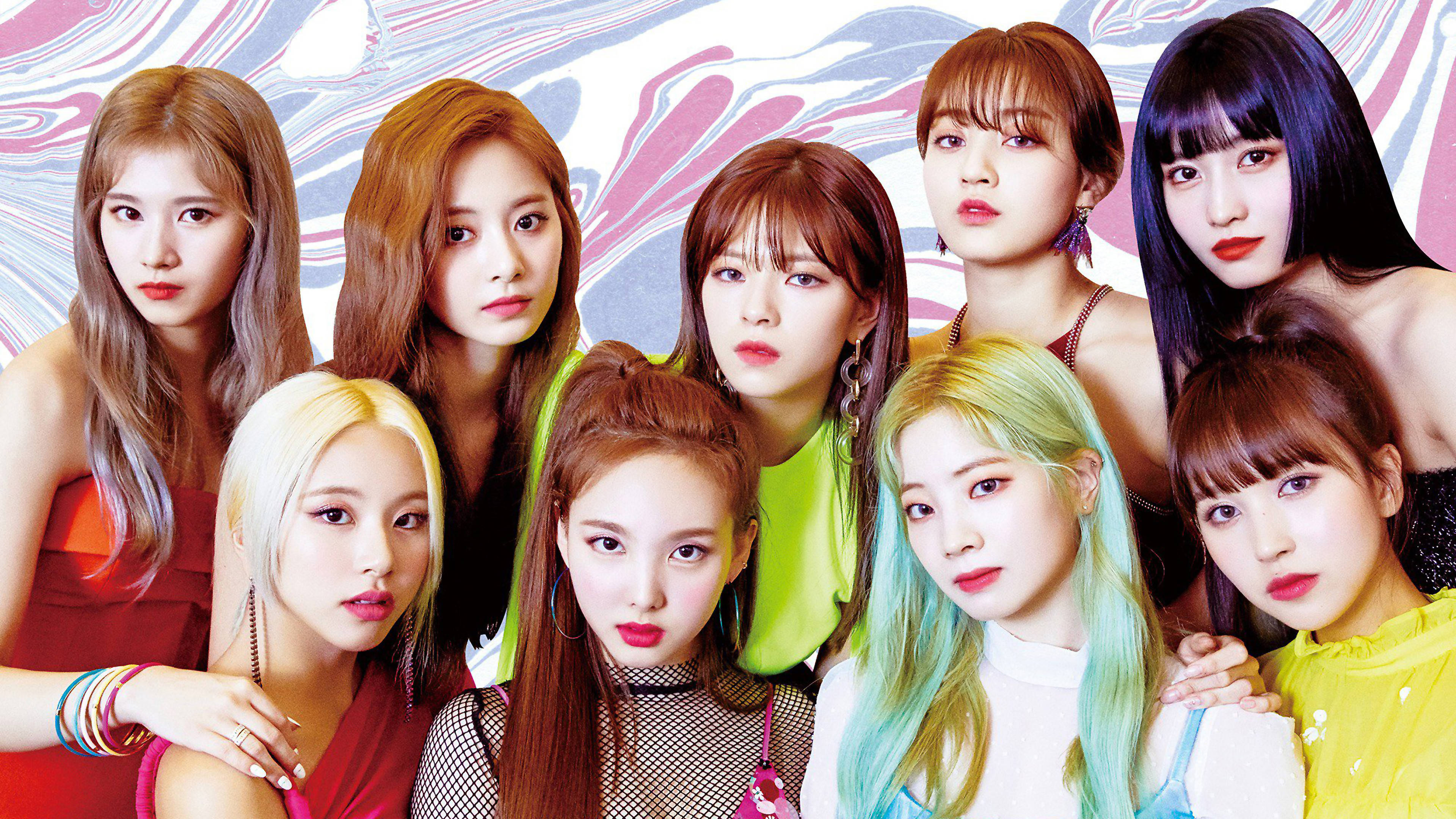 Kpop Aesthetic 桌布 壁紙 — 七位K-pop偶像在旋轉的粉紅色和藍色抽象背景前自信地擺姿勢，髮色大膽。