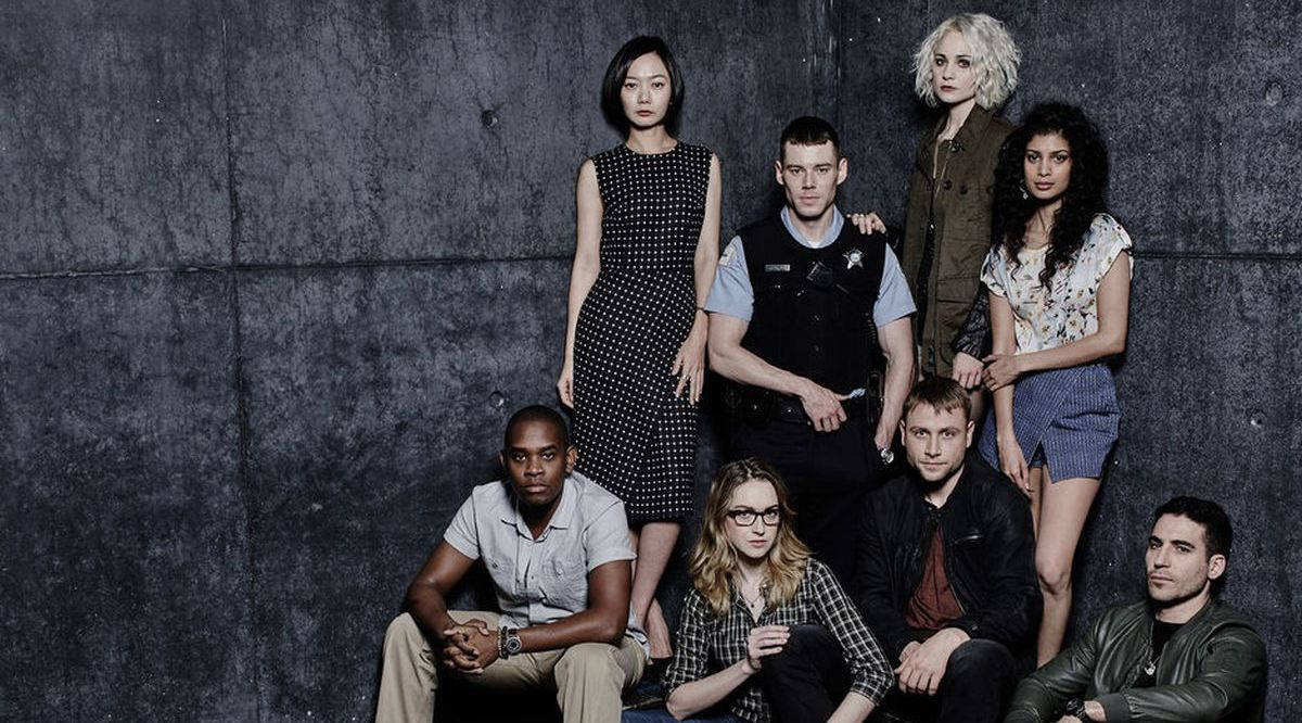 Sense8 桌布 壁紙 — 七位不同背景的人士在戲劇性的攝影棚拍攝中，自信地擺姿勢，背景是帶有紋理的深灰色混凝土牆。