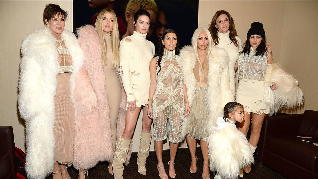 Kim Kardashian 桌布 壁紙 — 七位女士和一個小孩穿著華麗的白色皮草和珠飾服裝，在室內一起拍照。