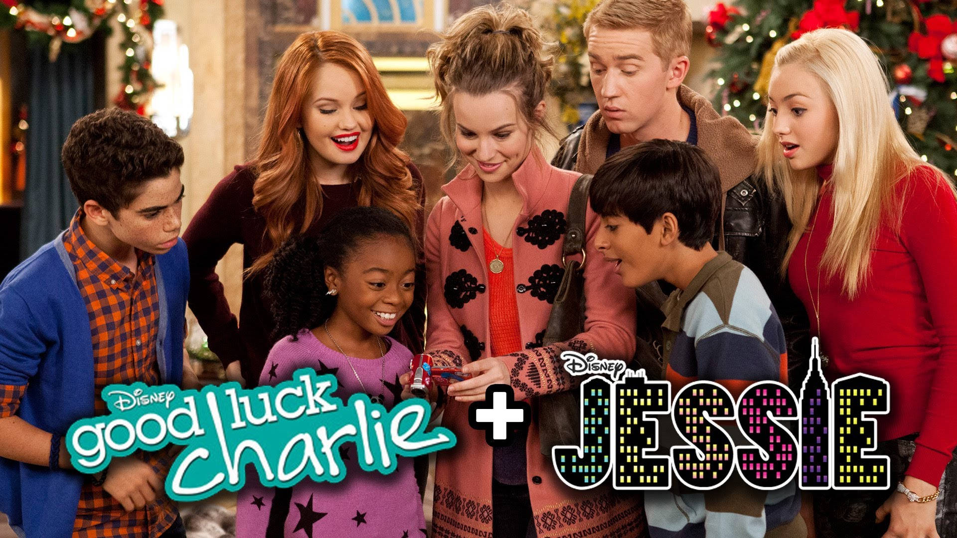 Good Luck Charlie 桌布 壁紙 — 七位年輕演員穿著節日服裝，緊密圍繞著一個小禮物，在溫暖燈光的室內聖誕場景中微笑並表現出驚喜和喜悅。