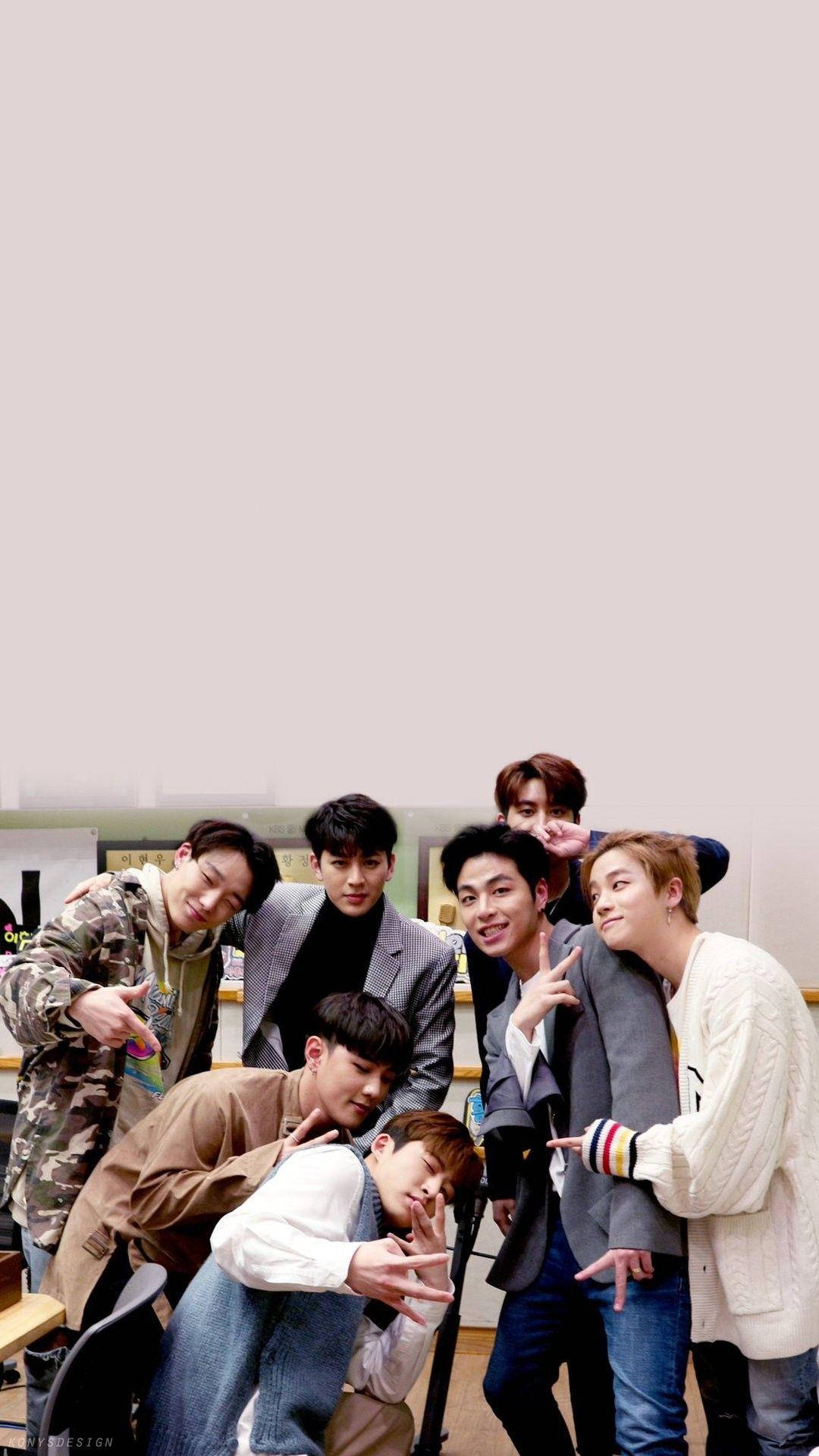 Ikon 桌布 壁紙 — 七位年輕男士身穿休閒服裝，在光線明亮的室內環境中一起擺出俏皮的姿勢。