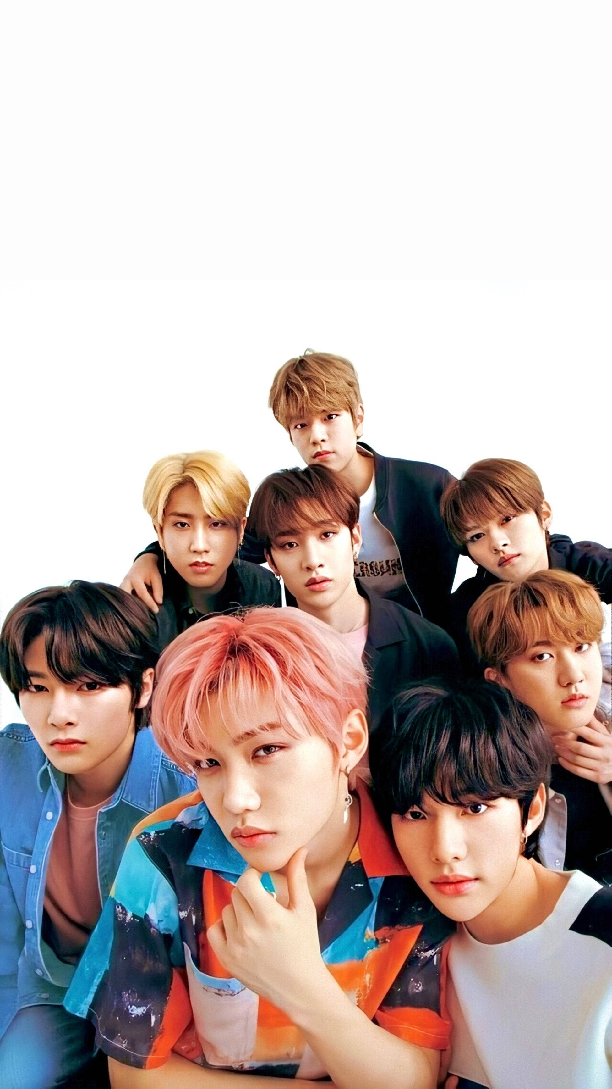 Stray Kids 桌布 壁紙 — 七位年輕男子，擁有色彩繽紛的頭髮和時尚的服裝，在純白背景前緊密地擺姿勢。