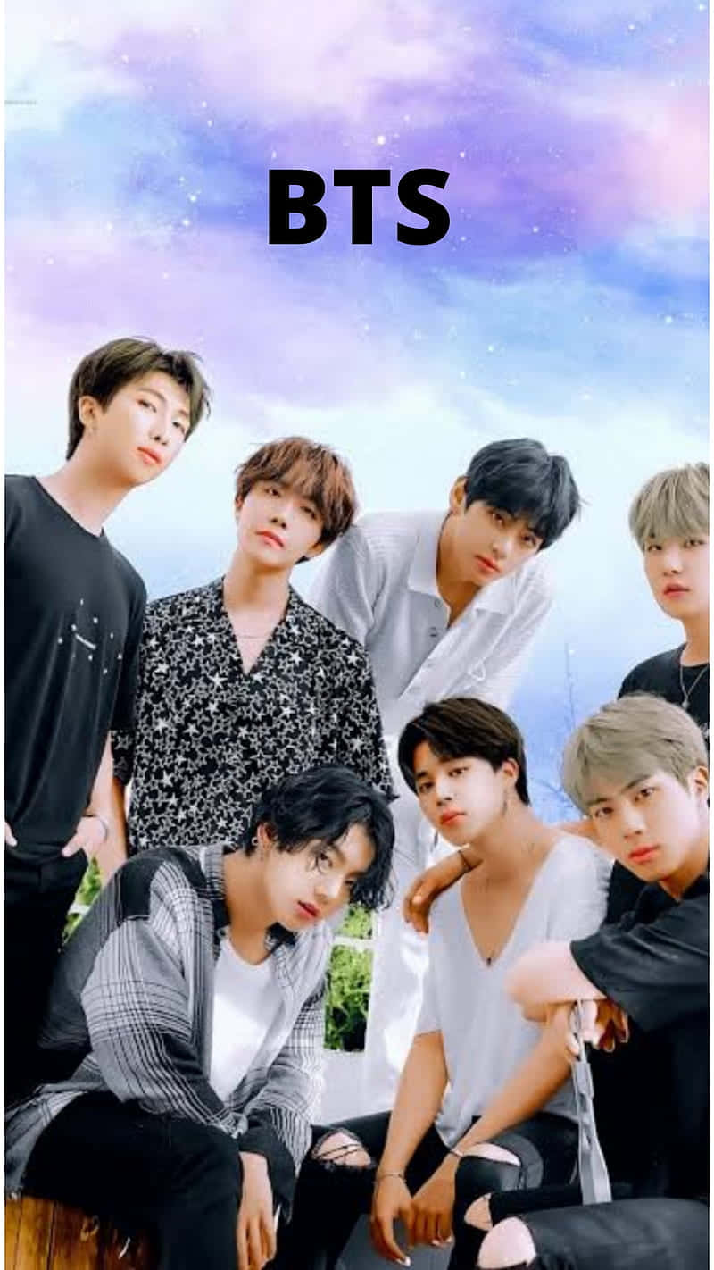 BTS 桌布 壁紙 — 七位年輕男性在夢幻的紫色和藍色星空背景下自信地擺姿勢，BTS 文字居中在他們上方。