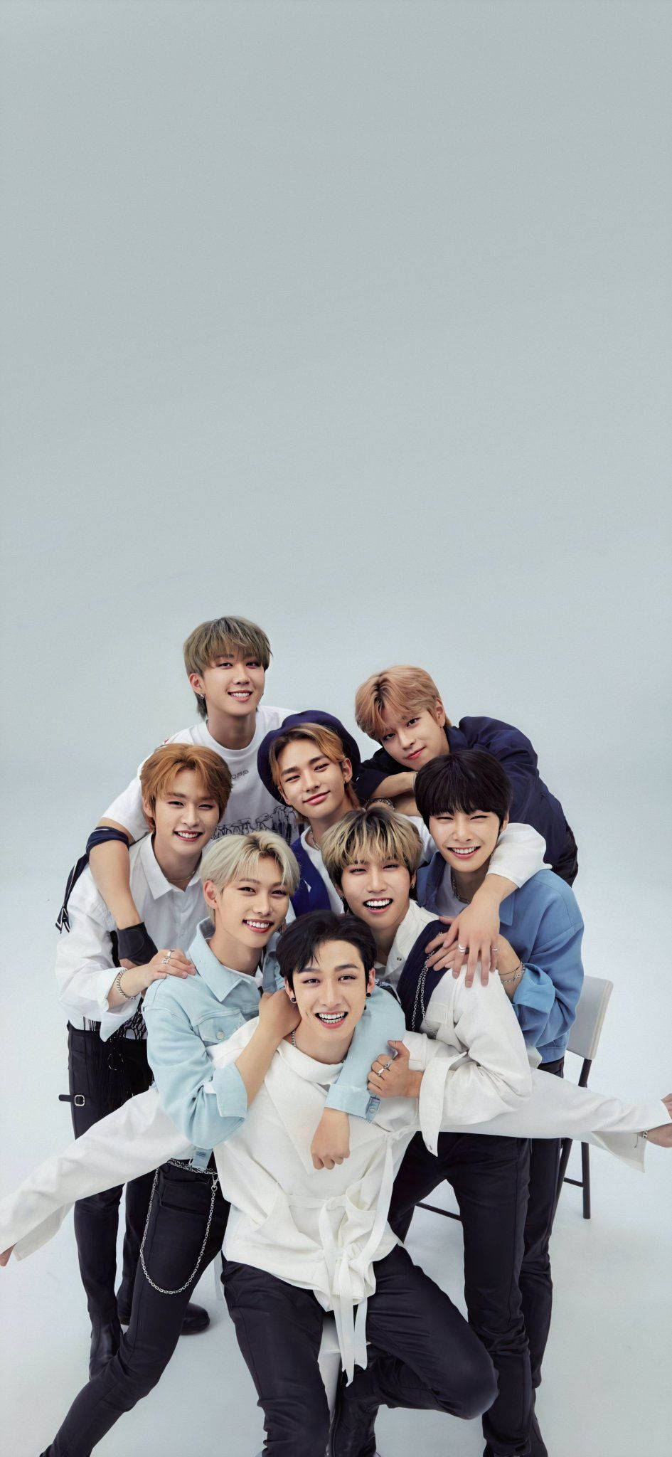 Stray Kids 桌布 壁紙 — 七位微笑的年輕男士穿著休閒服裝，在純淺灰色工作室背景前緊密地擺姿勢。