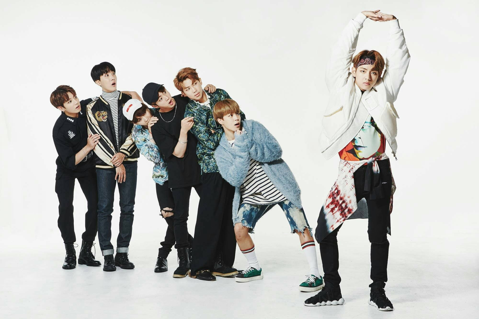 BTS 桌布 壁紙 — 七位時尚年輕男士在純白工作室背景下，穿著潮流街頭服飾擺出動感姿勢。