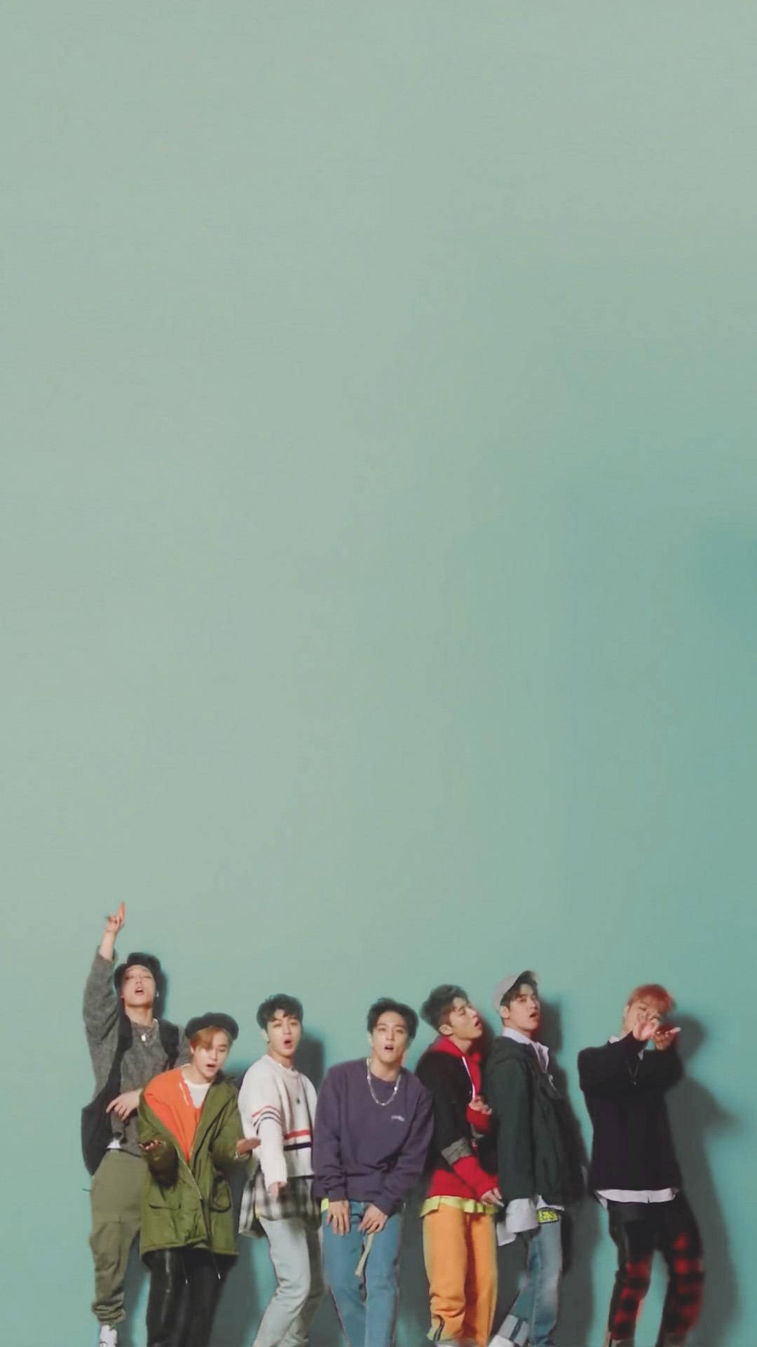 Ikon 桌布 壁紙 — 七位時尚年輕男士穿著色彩繽紛的街頭服飾，在純色青綠色背景前充滿活力地擺出俏皮姿勢。