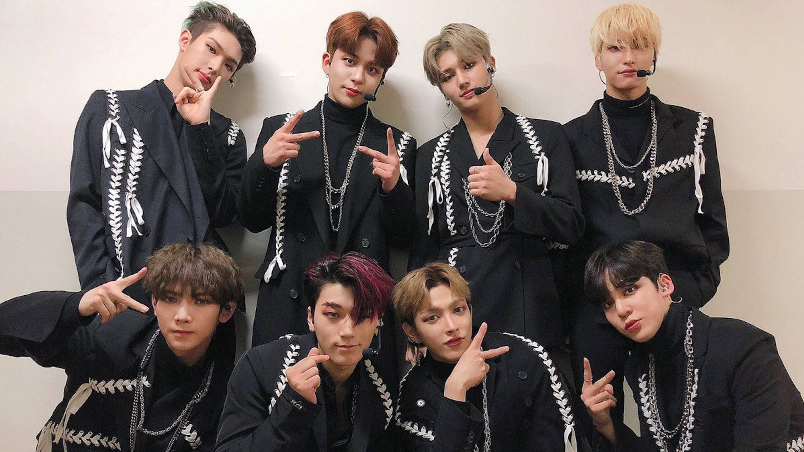 Ateez Desktop 桌布 壁紙 — 七位時尚年輕男士身穿搭配黑色服裝，飾有白色蕾絲細節，自信地靠著素牆擺姿勢。