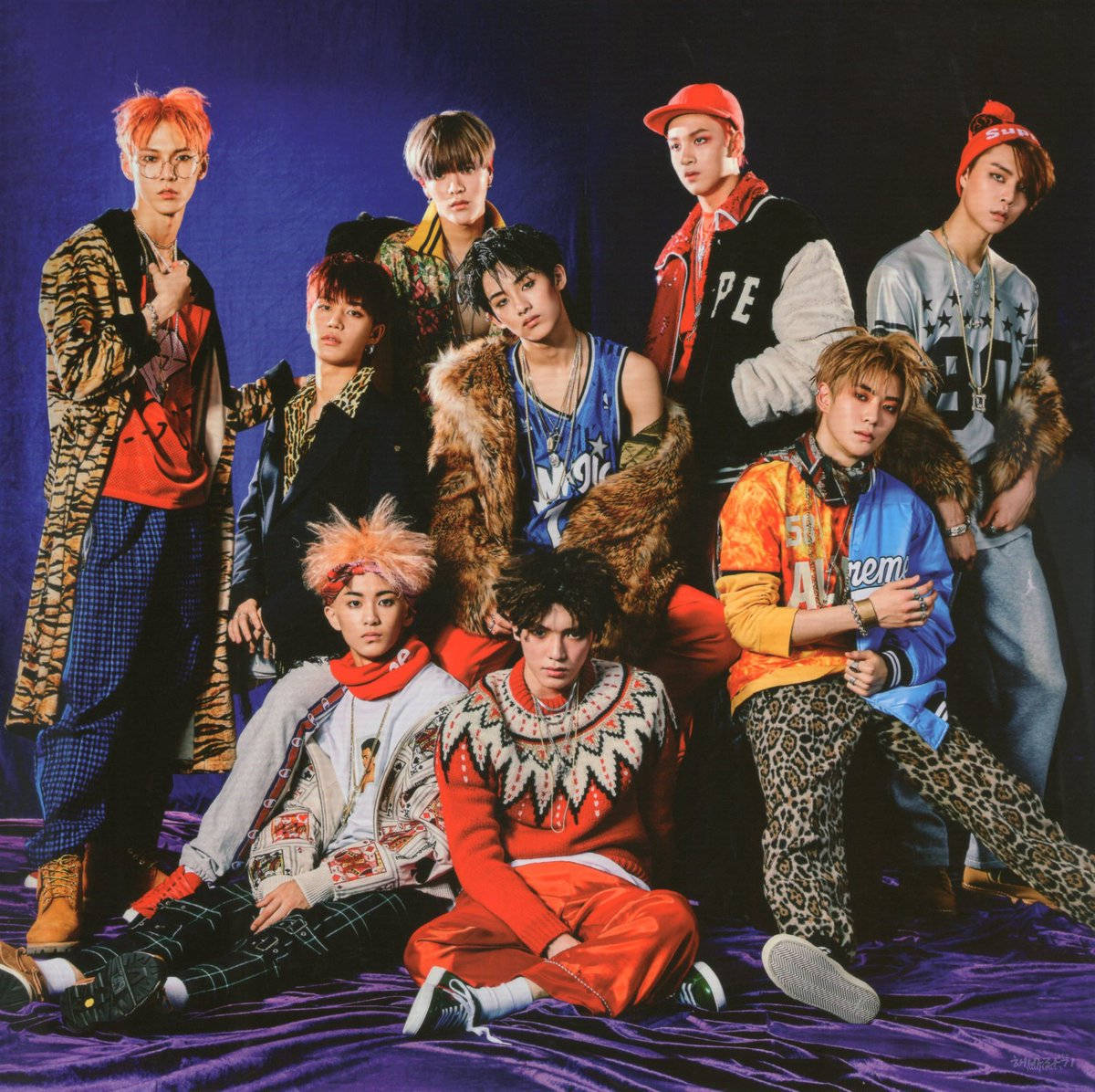 Nct 桌布 壁紙 — 七位時尚年輕男子穿著大膽街頭服飾，在深紫色背景和戲劇性燈光下自信擺姿勢。