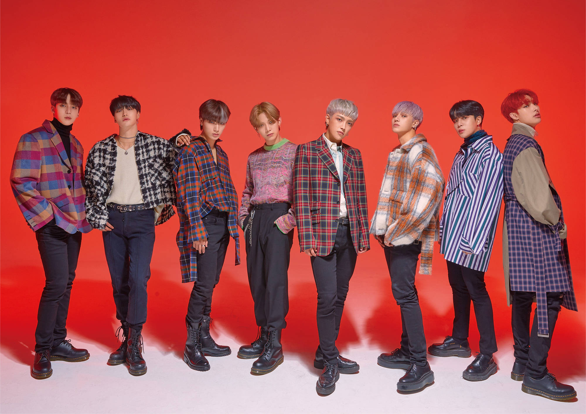 ateez 桌布 壁紙 — 七位時尚年輕男子身穿彩色格紋外套和靴子，在鮮紅色的攝影棚背景前自信擺姿勢。