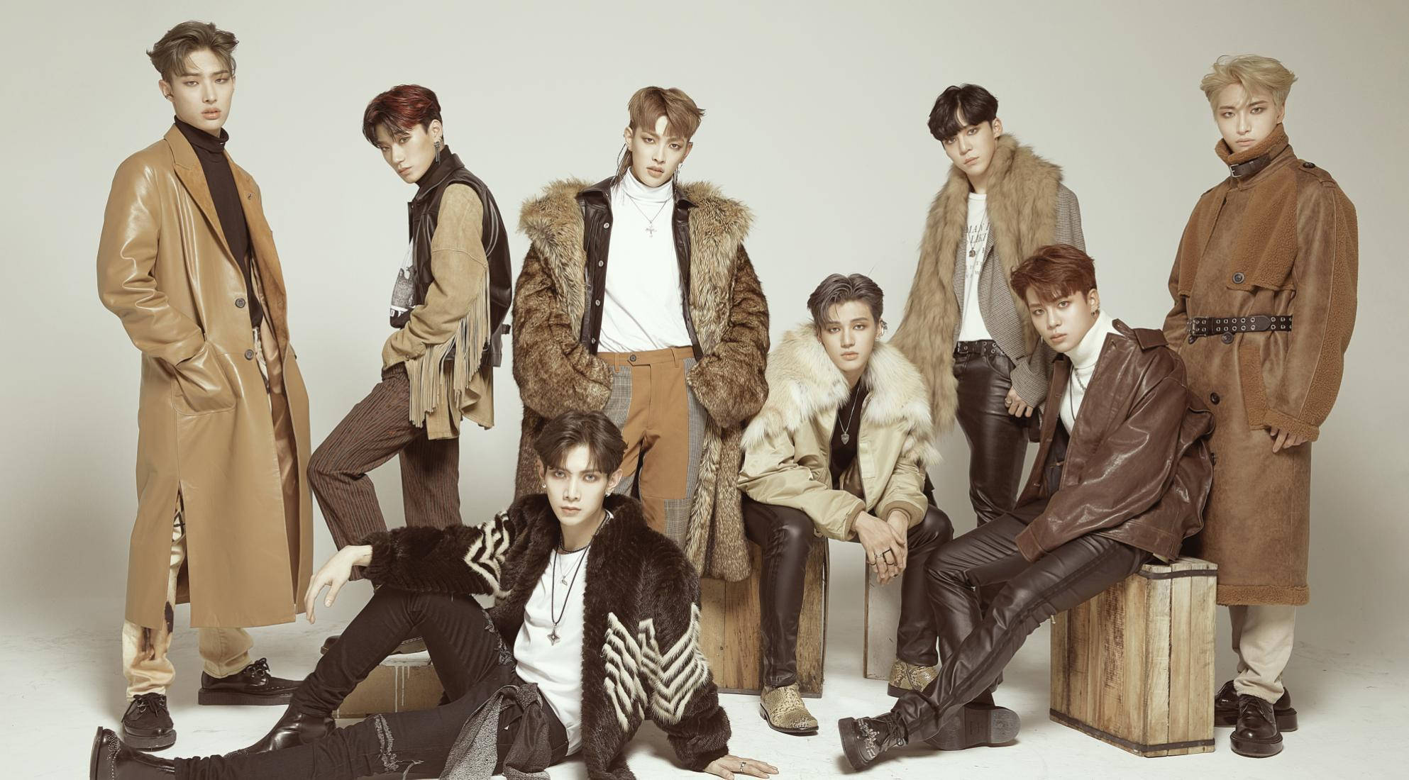 Ateez Desktop 桌布 壁紙 — 七位時尚男士身穿棕色皮革和毛皮大衣，在樸素的工作室背景前自信地擺姿勢。