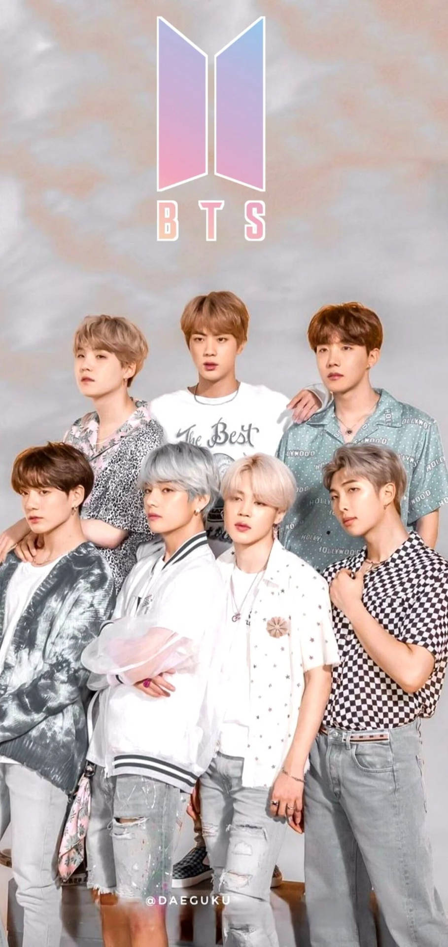 七位穿著時尚服裝的年輕男子在粉彩天空下與BTS標誌一起擺姿勢。 — BTS標誌 壁紙