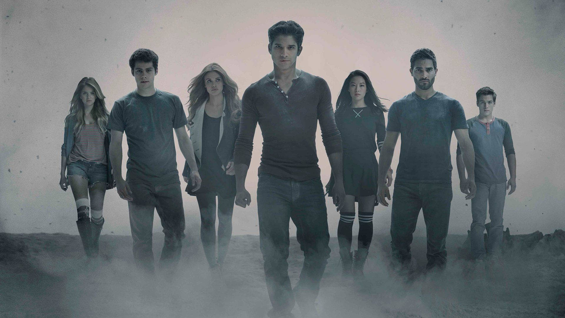 lydia martin 桌布 壁紙 — 七位穿著休閒服裝的年輕人站在霧氣瀰漫的荒涼景觀中，表情堅定。