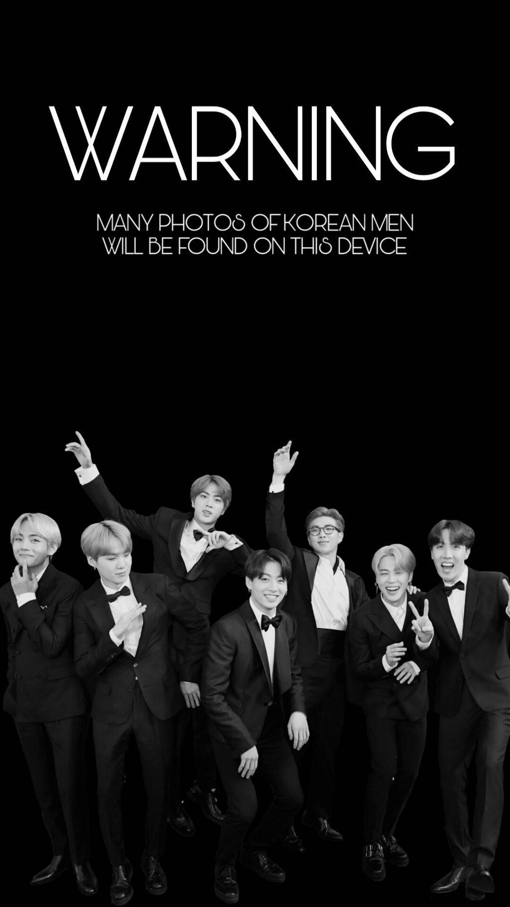 BTS 鎖定螢幕 桌布 壁紙 — 七位穿著黑色禮服的韓國男士在純黑背景前愉快地擺姿勢，並附有粗體白色文字警告他們的照片。
