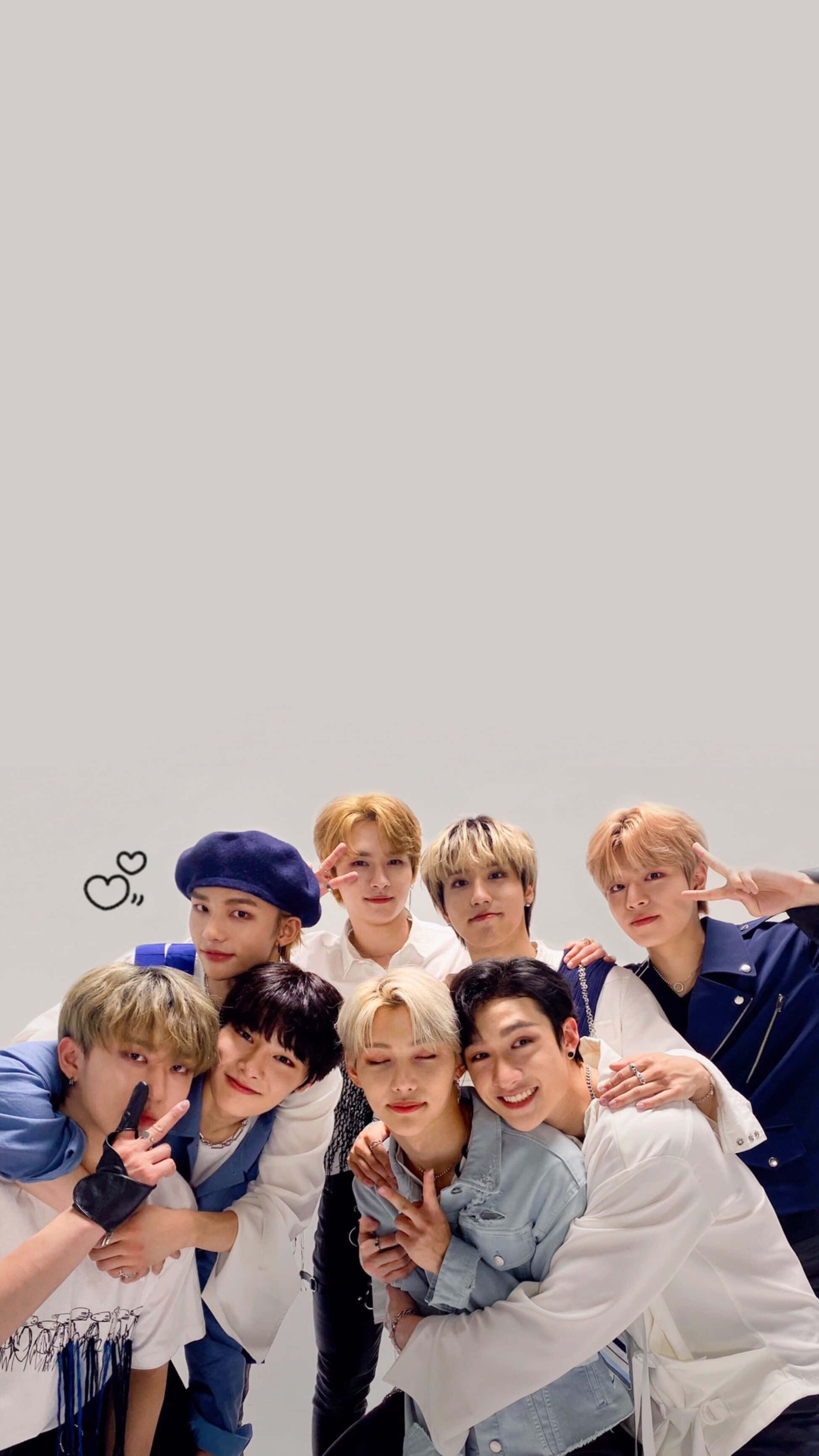 Stray Kids 2020 桌布 壁紙 — 七位身穿休閒服的年輕男士在帶有心形塗鴉的純灰色背景前頑皮地擺姿勢。