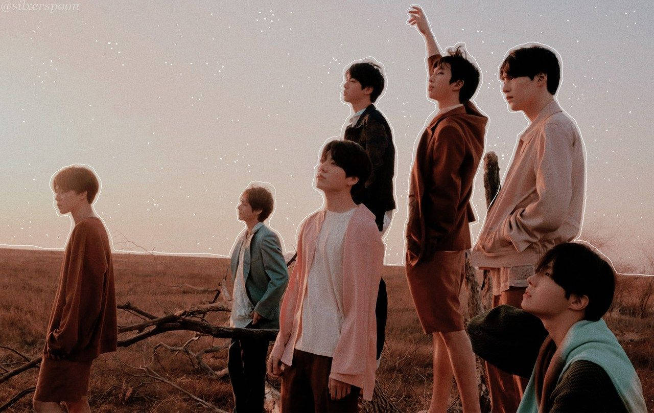 BTS 筆電 桌布 壁紙 — 七位身穿大地色系服裝的年輕男子，站在星空暮色下的沙漠原野中。