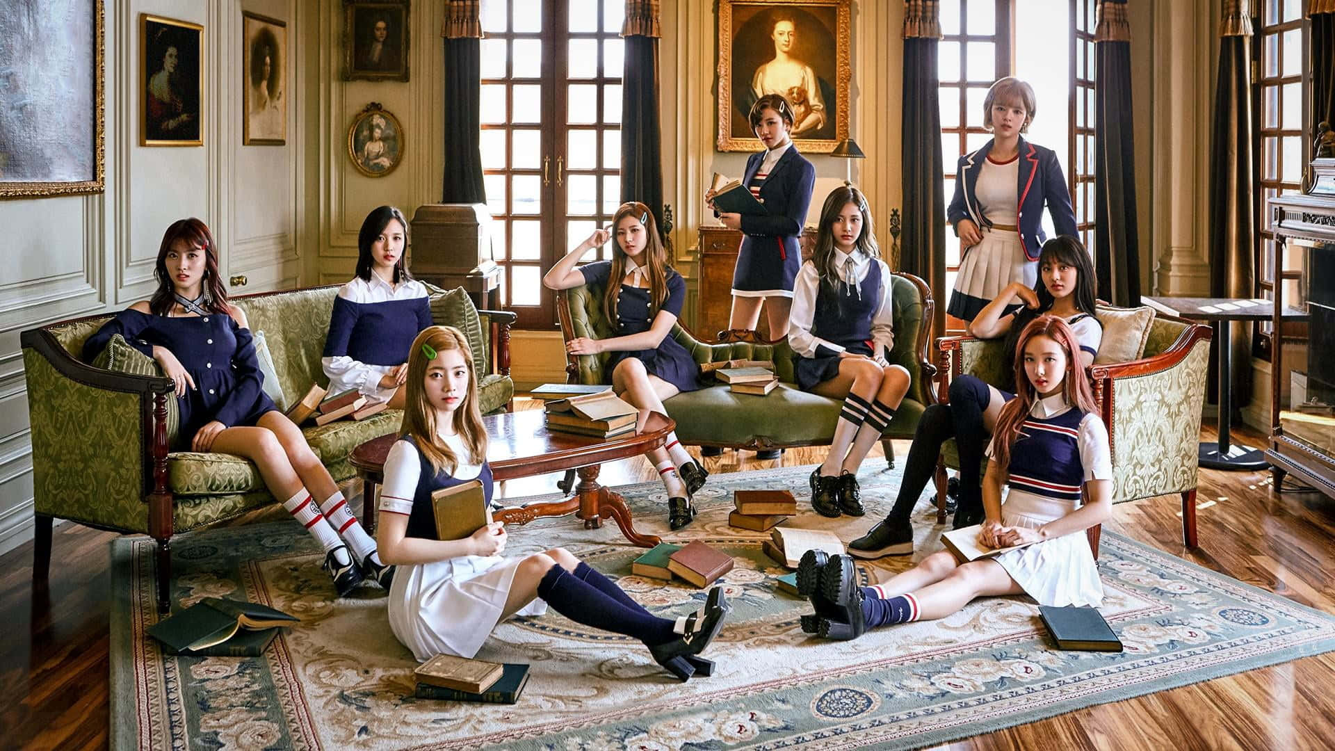twice 桌布 壁紙 — 七位身穿復古校服的年輕女性在一個充滿書籍和古董家具的宏偉、陽光充足的圖書館中優雅地擺姿勢。
