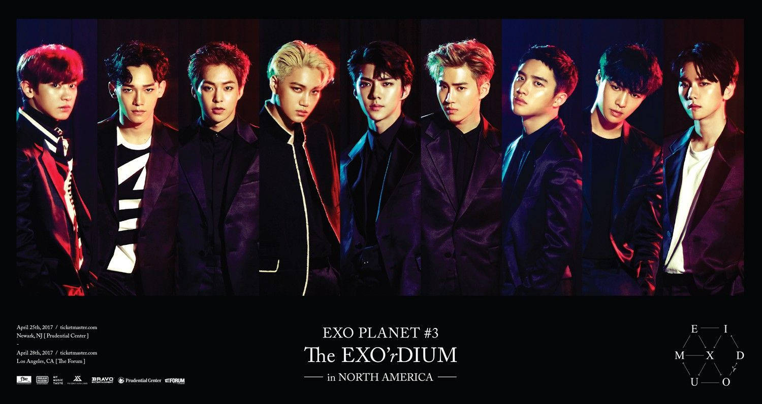 K-pop 桌布 壁紙 — 七位身穿時尚深色西裝、髮色鮮豔的男性，在陰暗的背景前自信地擺姿勢。