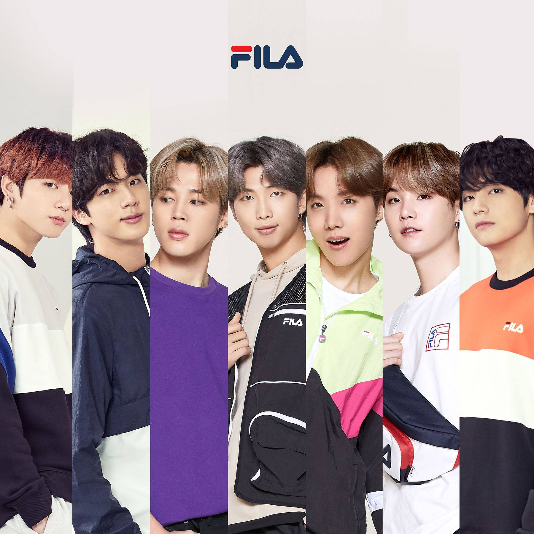 Fila 桌布 壁紙 — 七位身穿色彩繽紛FILA運動服的年輕男性，在潔白背景前站成一排，上方有FILA標誌。