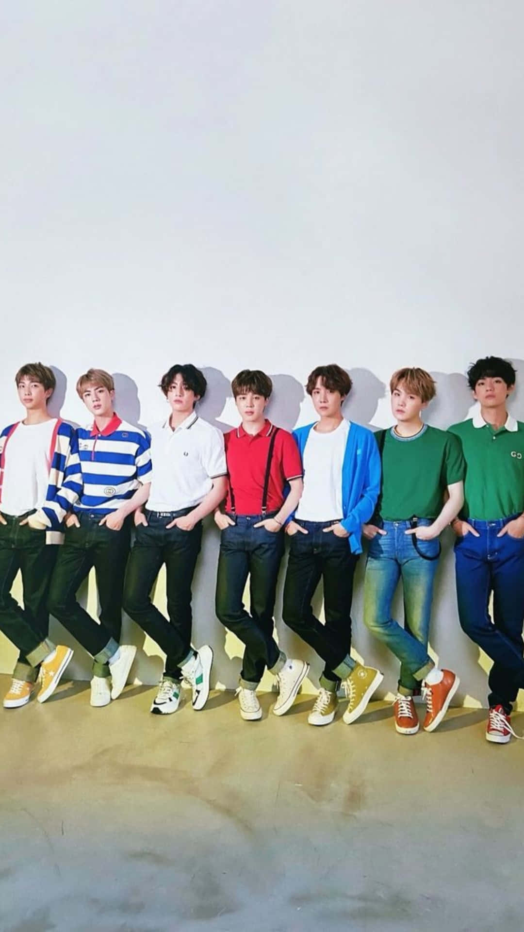 BTS 桌布 壁紙 — 七位身穿色彩繽紛休閒服裝的年輕男性，以自信姿態靠在一面純白牆上。