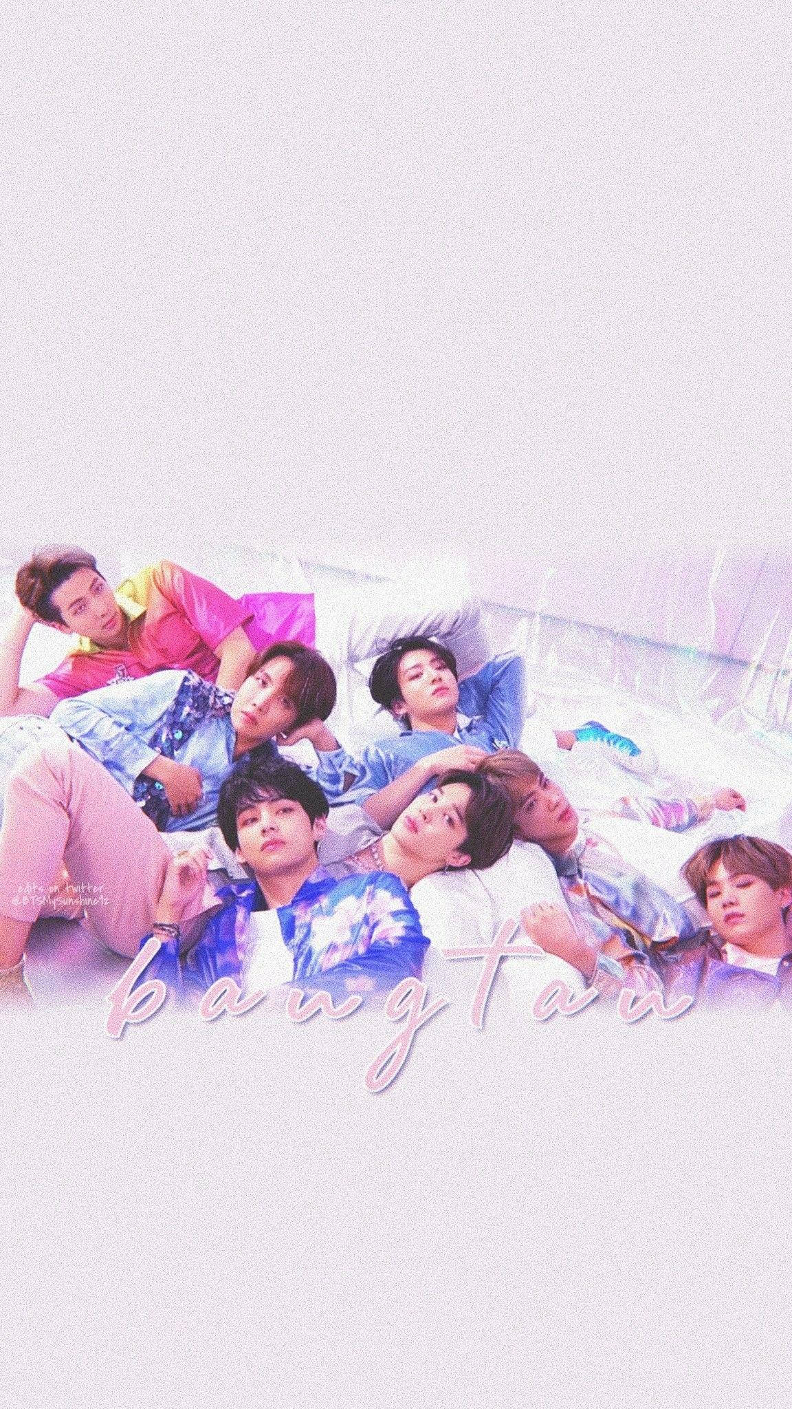 BTS 桌布 壁紙 — 七位身穿色彩繽紛服裝的年輕男子，在柔和粉彩燈光及下方發光的「bangtan」標誌的床上悠閒地躺著。