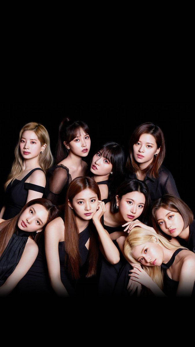 twice 桌布 壁紙 — 七位身穿黑色連衣裙的女性在純黑色背景下親密擺姿勢，柔和燈光凸顯她們的表情。