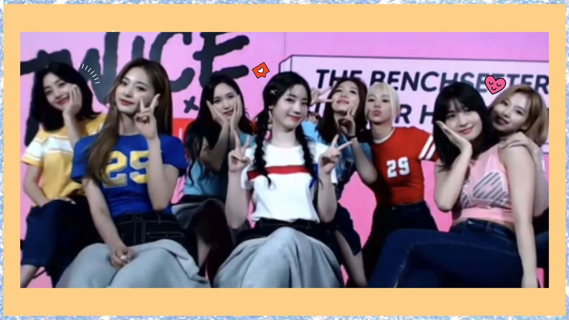 Cute Kpop 桌布 壁紙 — 七位面帶微笑的K-pop女孩穿著色彩繽紛的服裝，在帶有「TWICE」品牌的粉紅色舞台背景上愉快地擺姿勢。