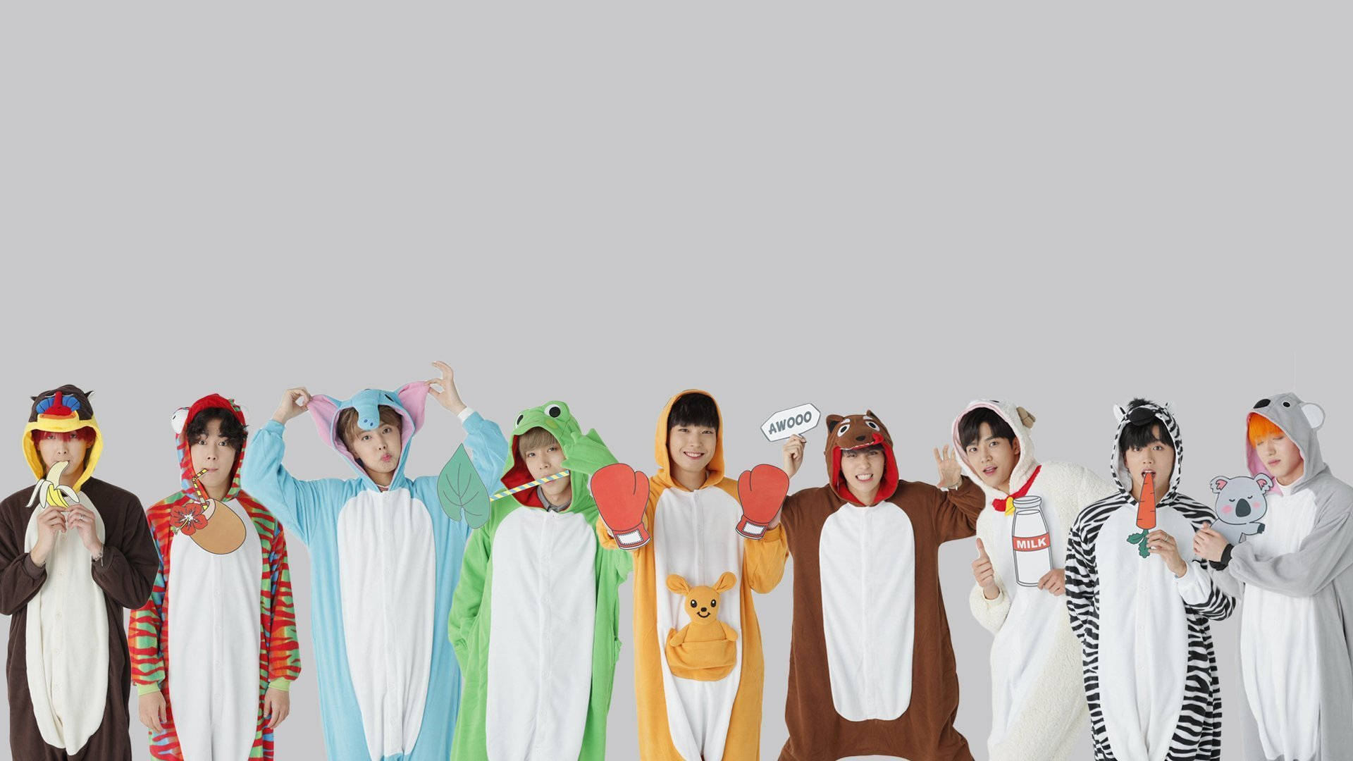 bts 2021 desktop 桌布 壁紙 — 七個人穿著色彩繽紛的動物連體衣，在純灰色背景前拿著道具愉快地擺姿勢。
