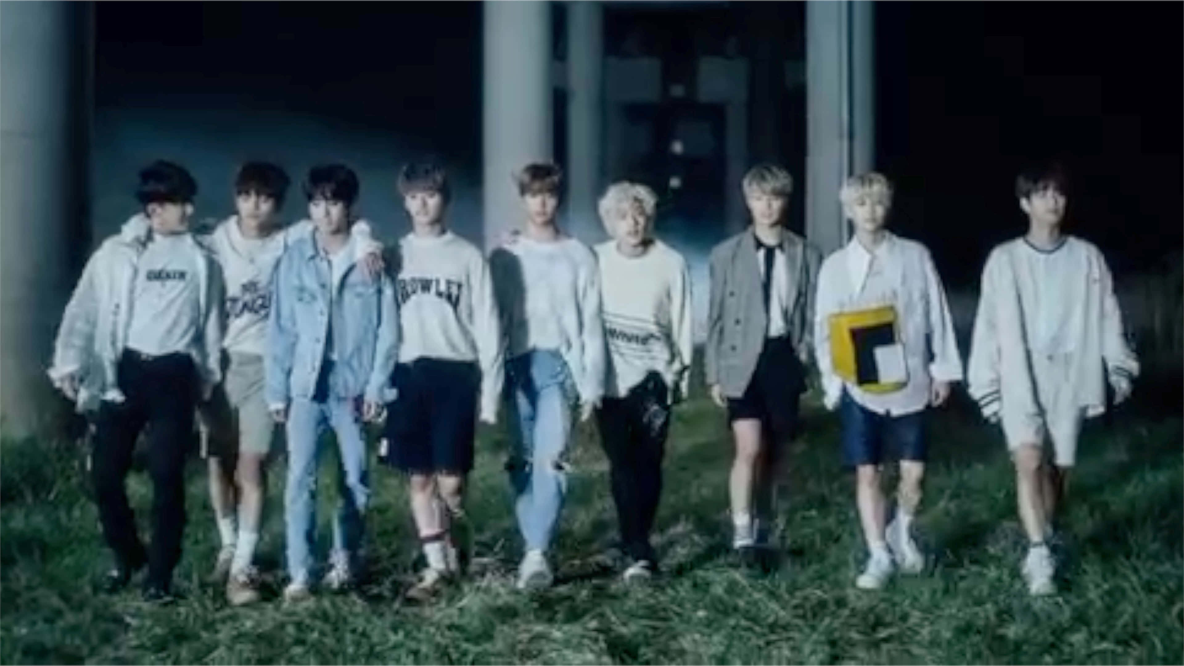 Stray Kids 2020 桌布 壁紙 — 七個年輕男子身穿休閒街頭服飾，在夜間昏暗的人造燈光下排成一列站在草地上。