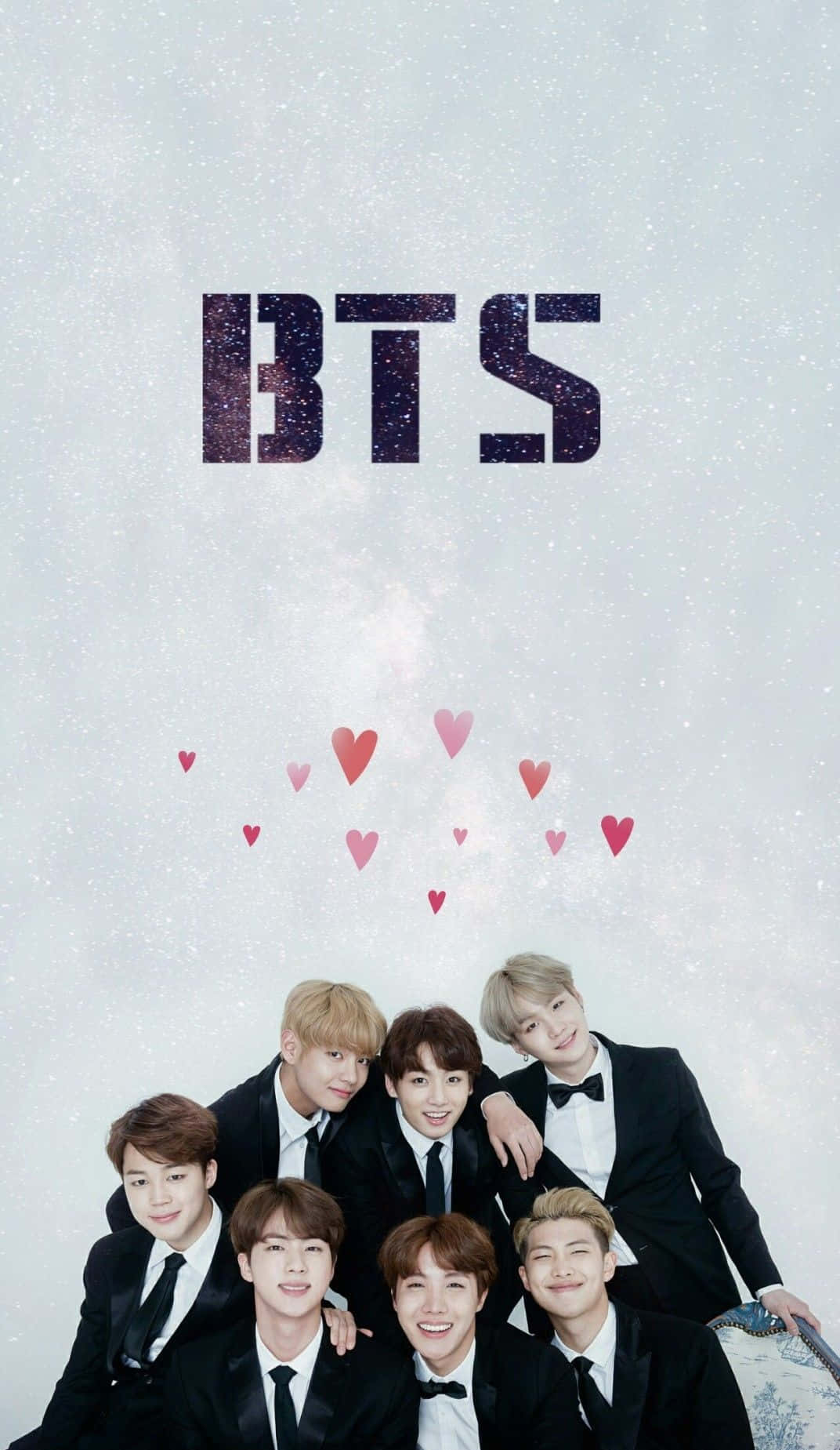 Bangtan Sonyeondan 桌布 壁紙 — 七個微笑的男人穿著黑色燕尾服，在閃爍的BTS標誌和漂浮的粉紅色愛心下方，於雪景背景中一起擺姿勢。