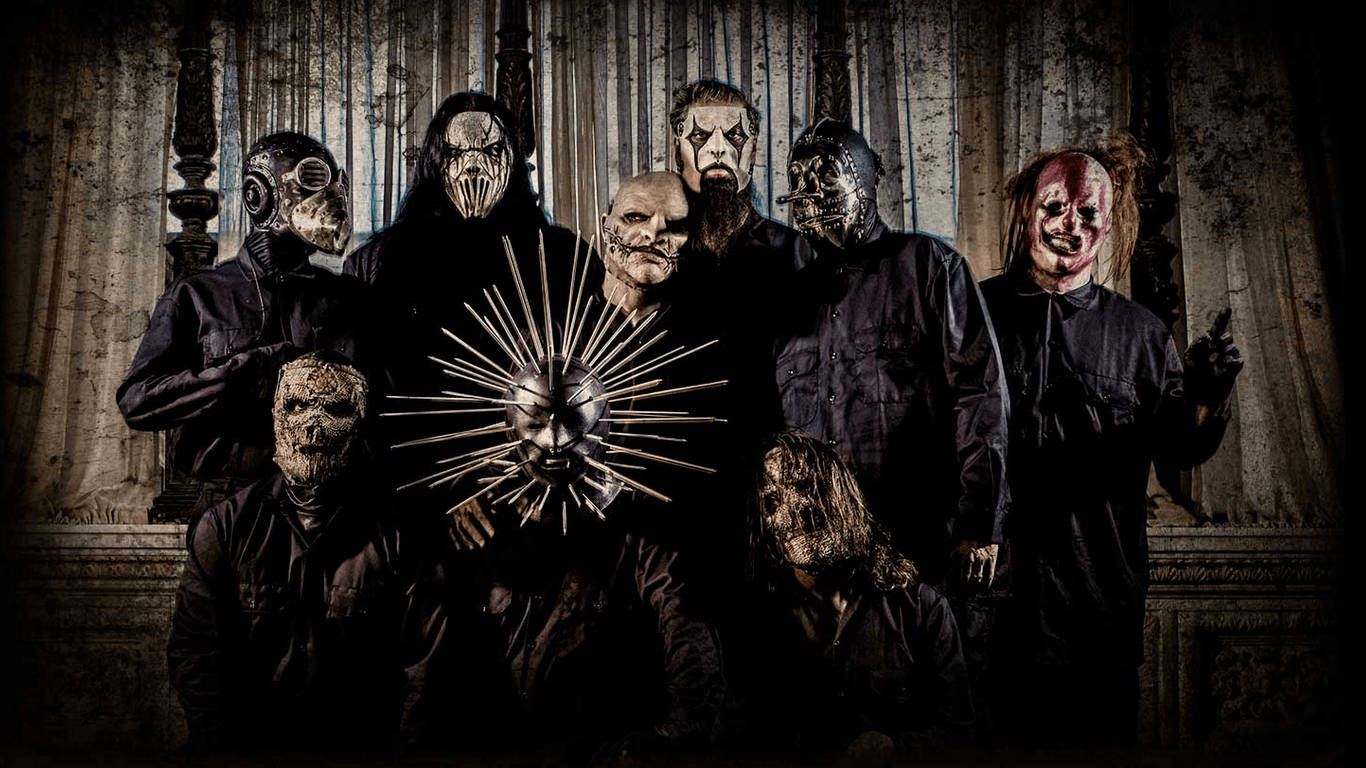 Slipknot 桌布 壁紙 — 七個戴面具、身穿深色衣服的人物站在一個哥德式大廳中，大廳有華麗的柱子和戲劇性的燈光。